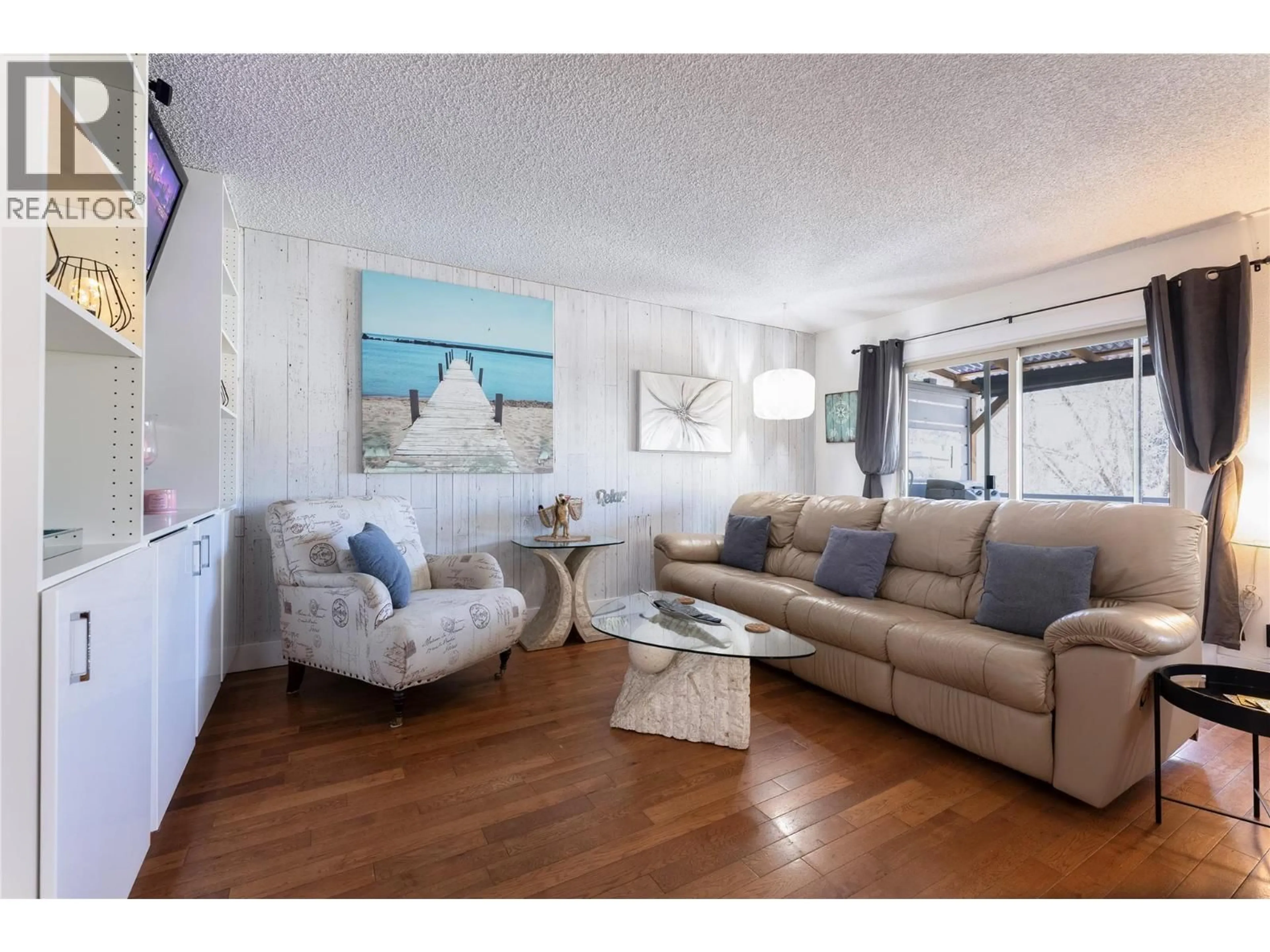 Living room with furniture, wood/laminate floor for 4171 LAKESHORE ROAD, Kelowna British Columbia V1W1W1