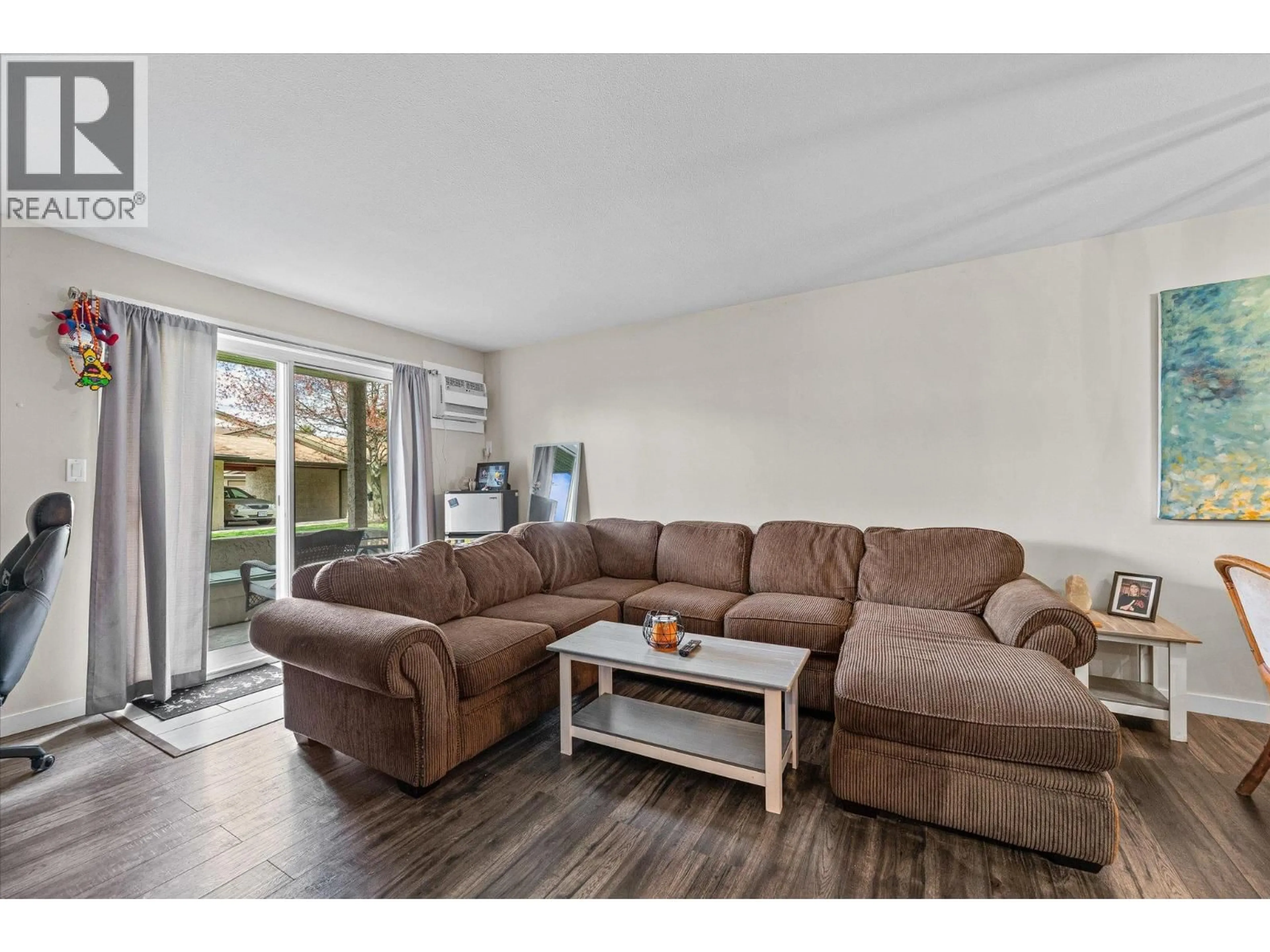 Living room with furniture, wood/laminate floor for 112 - 3842 GORDON DRIVE, Kelowna British Columbia V1W3G4