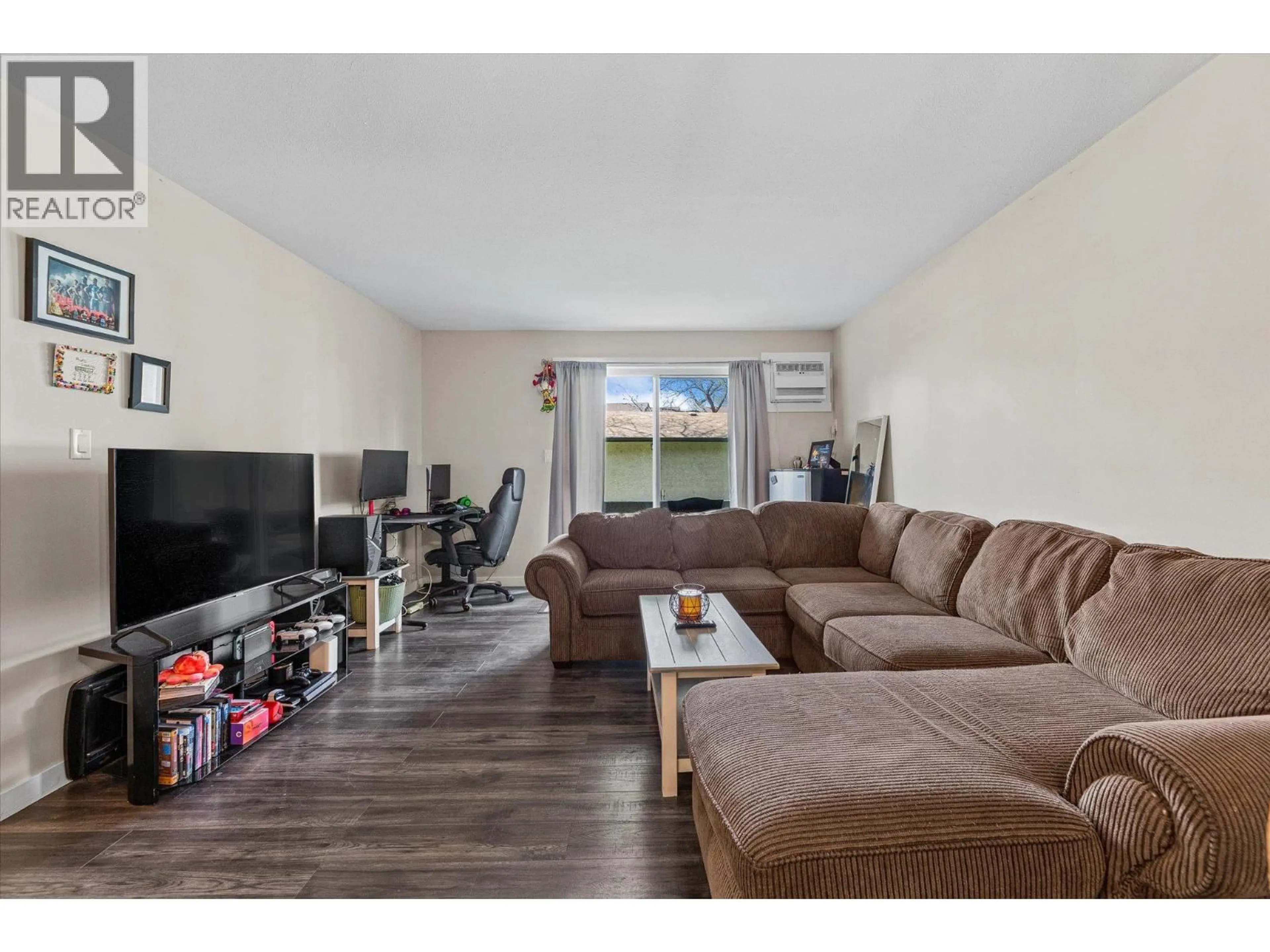 Living room with furniture, wood/laminate floor for 112 - 3842 GORDON DRIVE, Kelowna British Columbia V1W3G4
