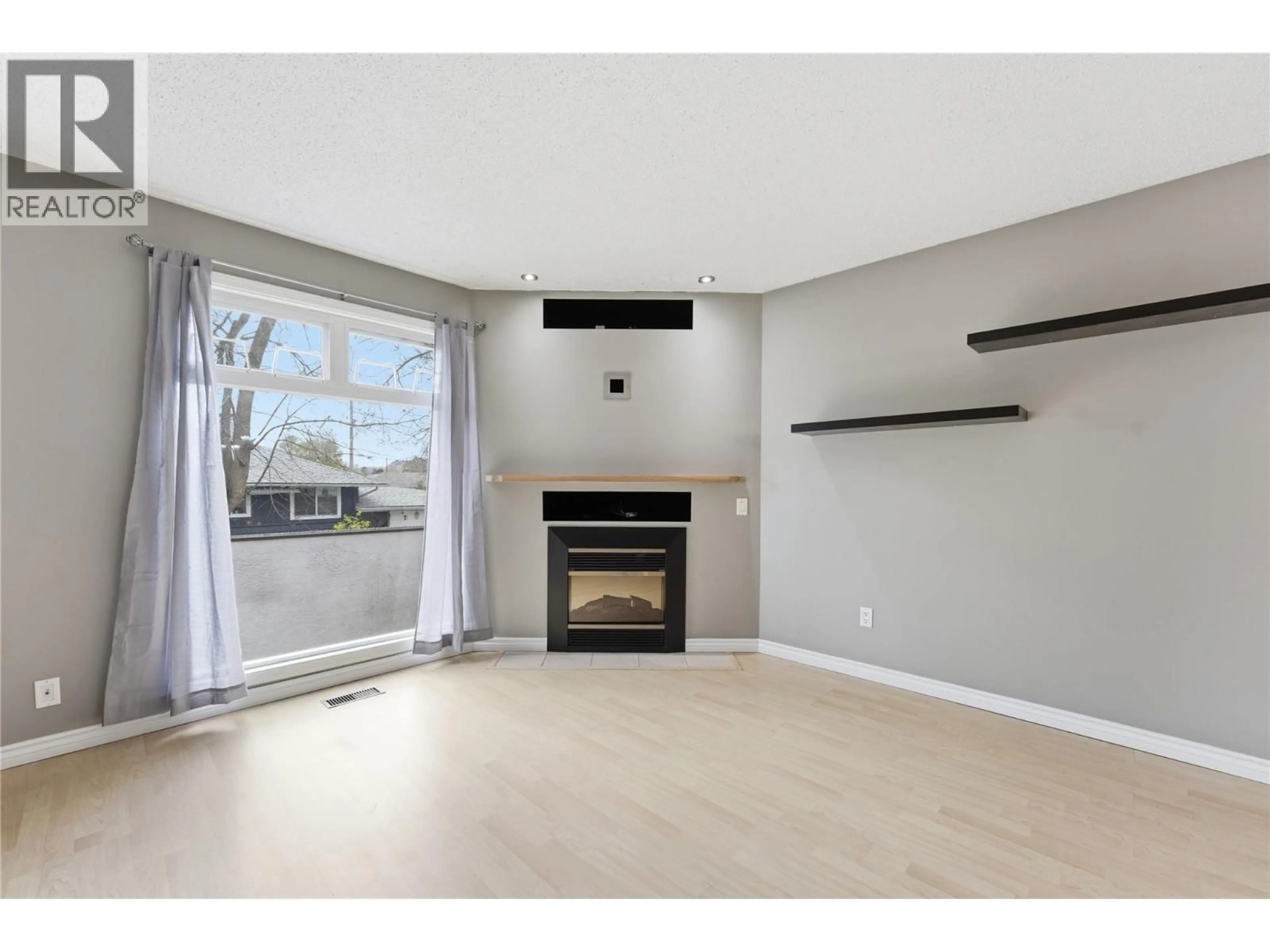Living room with furniture, wood/laminate floor for 205 - 2100 43 AVENUE, Vernon British Columbia V1T3K5