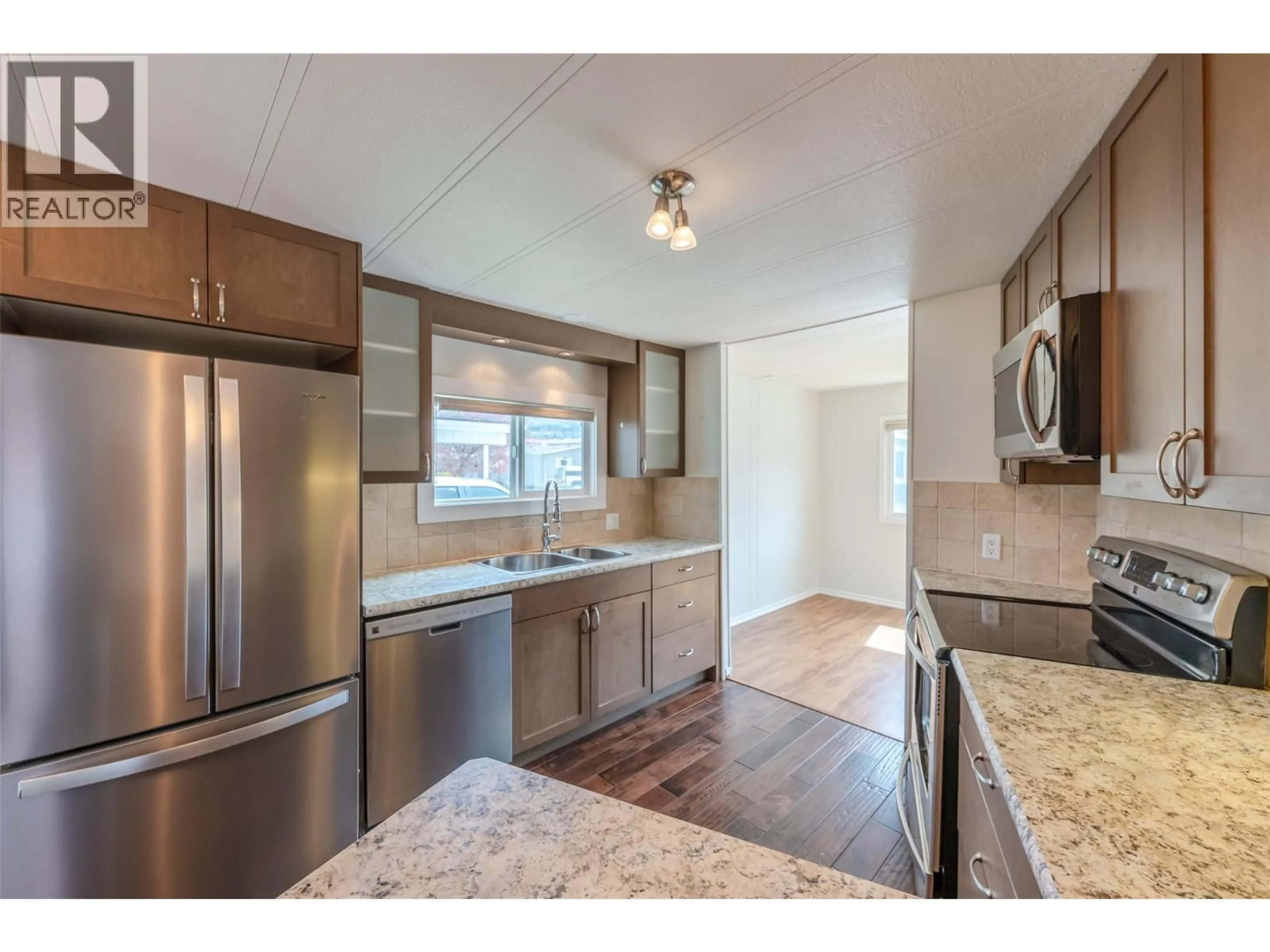 Open concept kitchen, wood/laminate floor for 318 - 321 YORKTON AVENUE, Penticton British Columbia V2A3V6