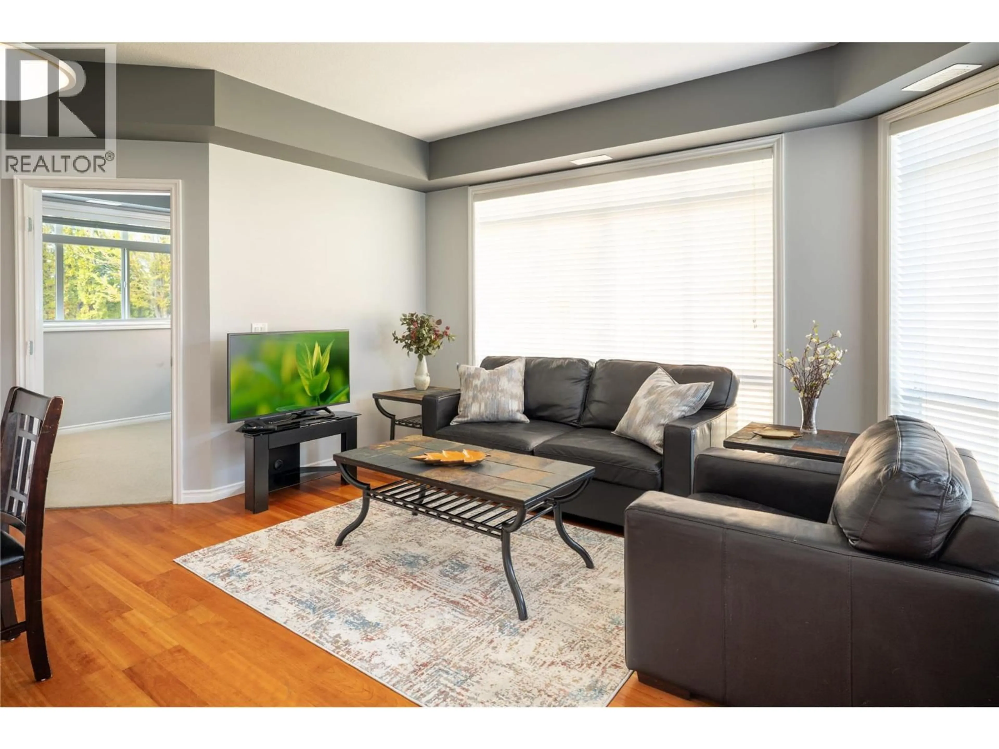 Living room with furniture, wood/laminate floor for 109 - 3570 WOODSDALE ROAD, Lake Country British Columbia V4V1Y9