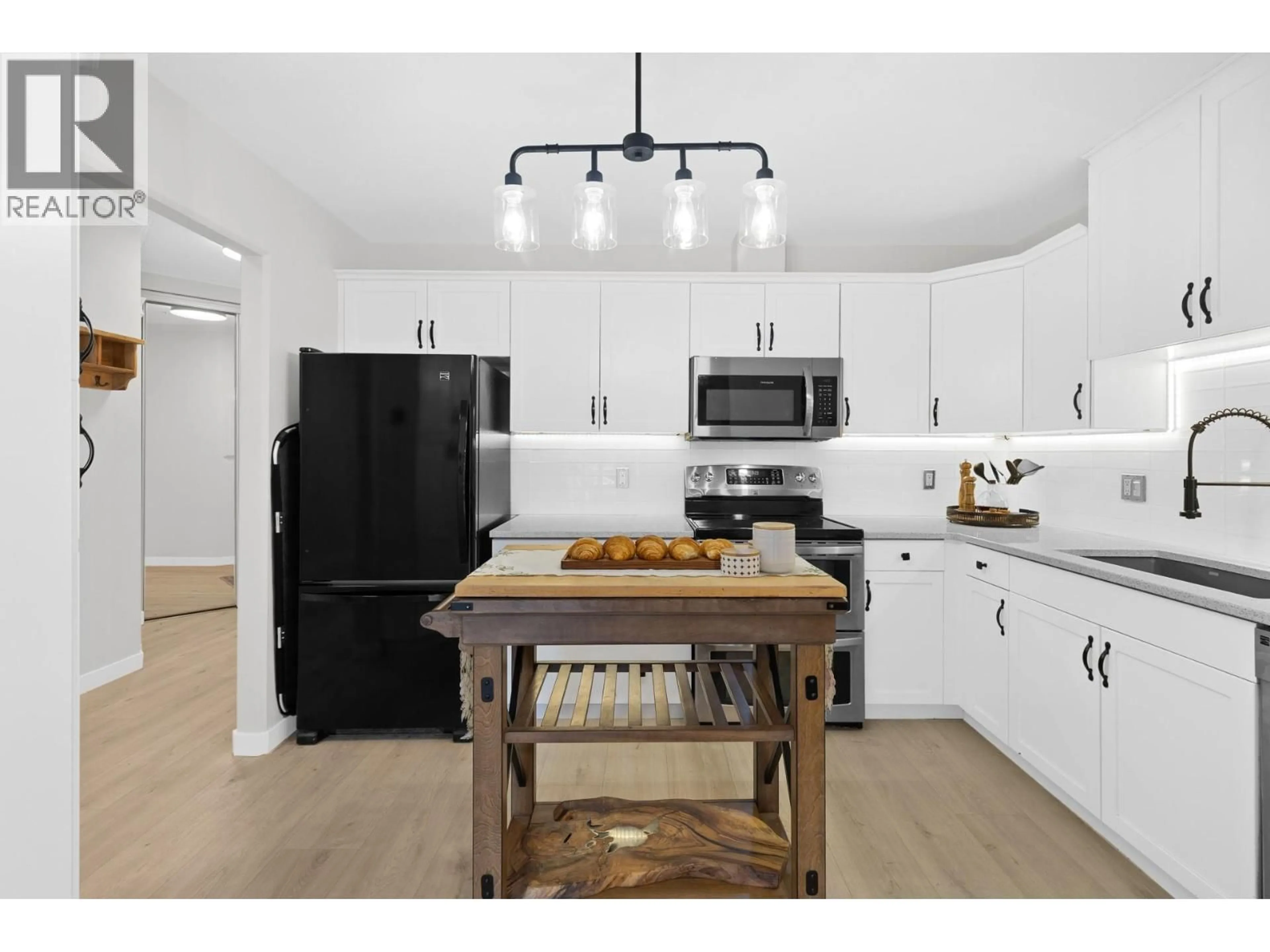 Open concept kitchen, wood/laminate floor for 106 - 303 WHITMAN ROAD, Kelowna British Columbia V1V2P3