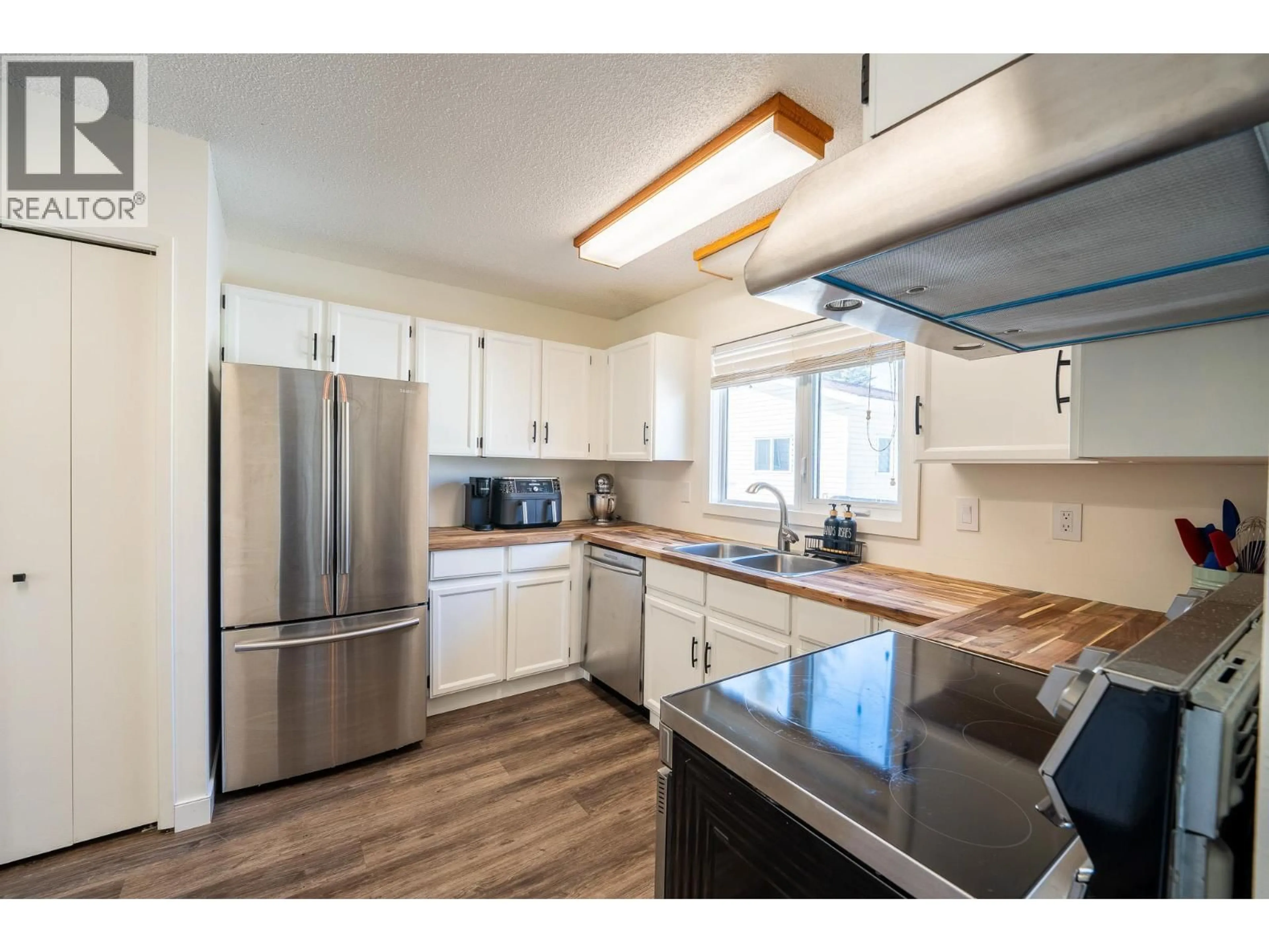 Open concept kitchen, wood/laminate floor for 10713 CYPRUS COURT, Dawson Creek British Columbia V1G4N1
