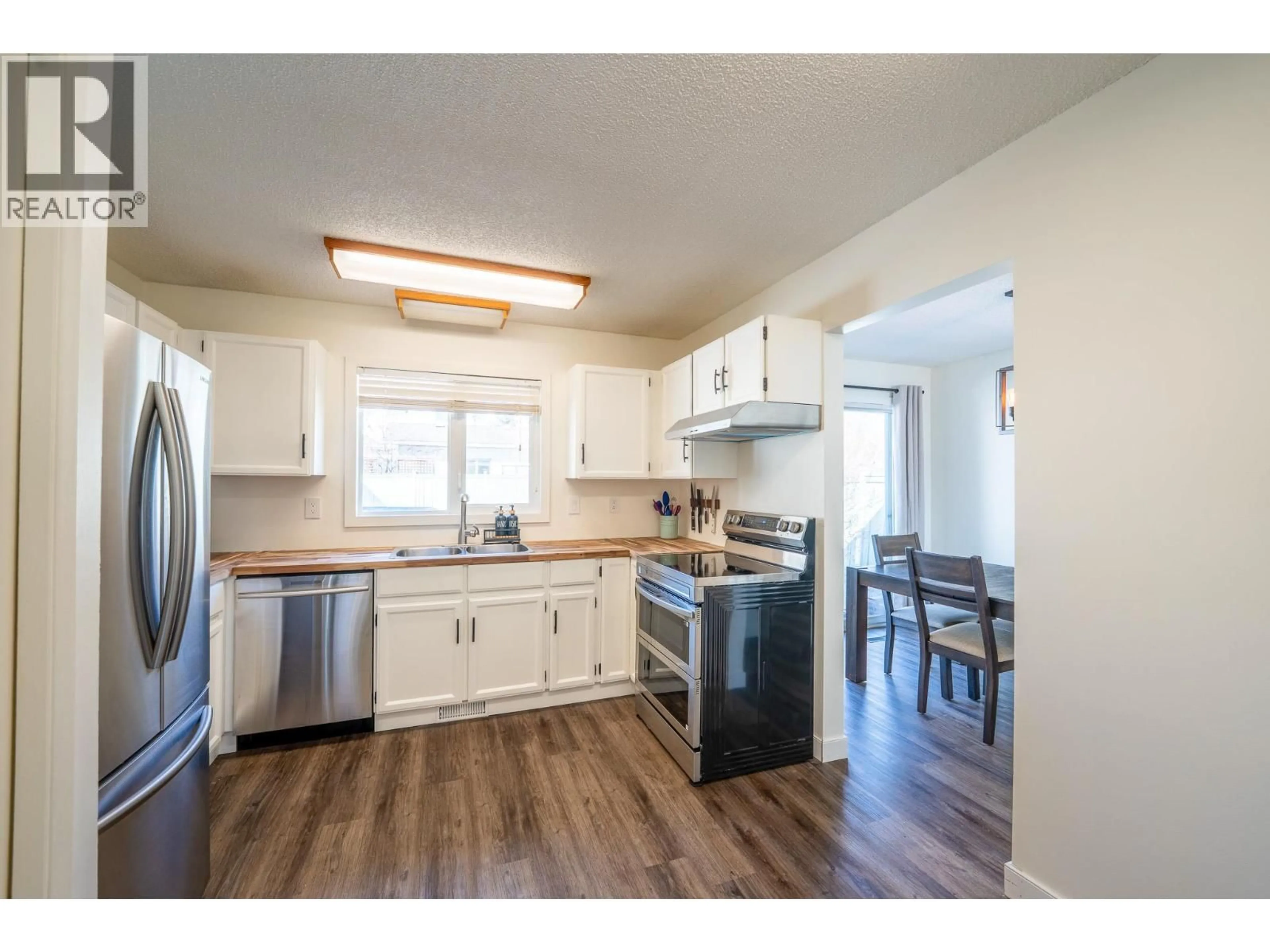 Open concept kitchen, wood/laminate floor for 10713 CYPRUS COURT, Dawson Creek British Columbia V1G4N1