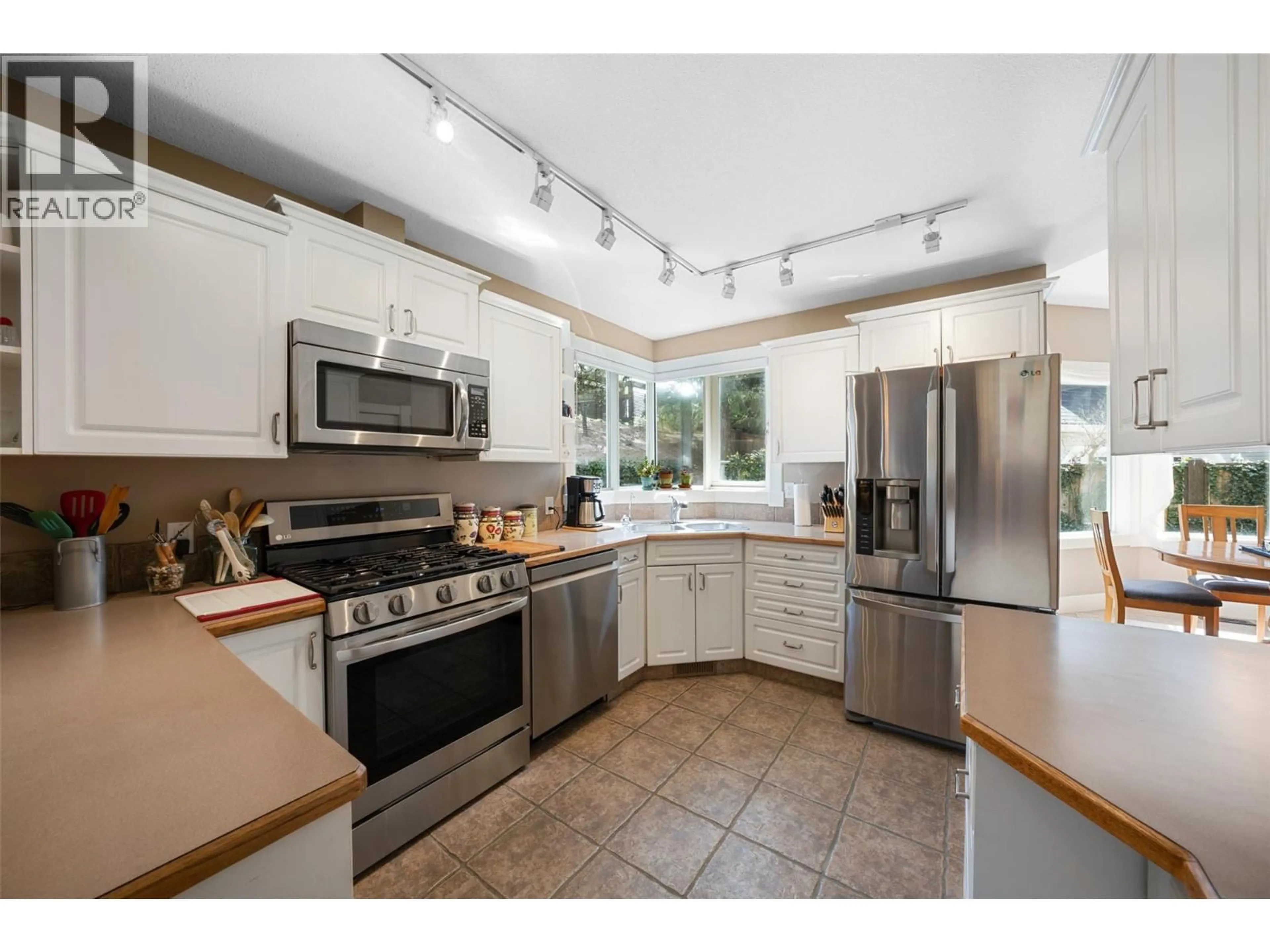 Open concept kitchen, ceramic/tile floor for 205 MERLIN COURT, Kelowna British Columbia V1V1N2