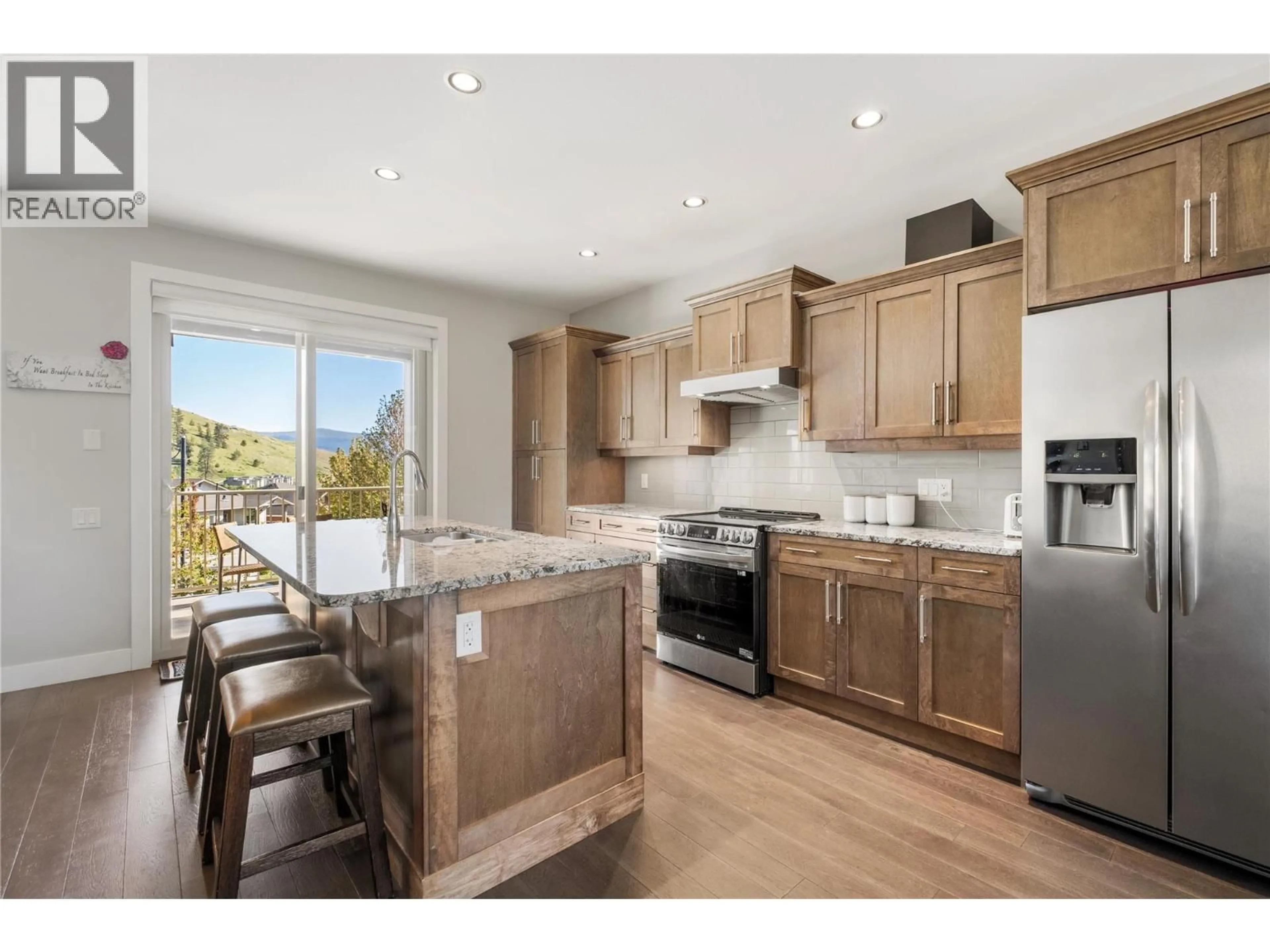 Open concept kitchen, wood/laminate floor for 1852 SPLIT RAIL PLACE, Kelowna British Columbia V1P1R1