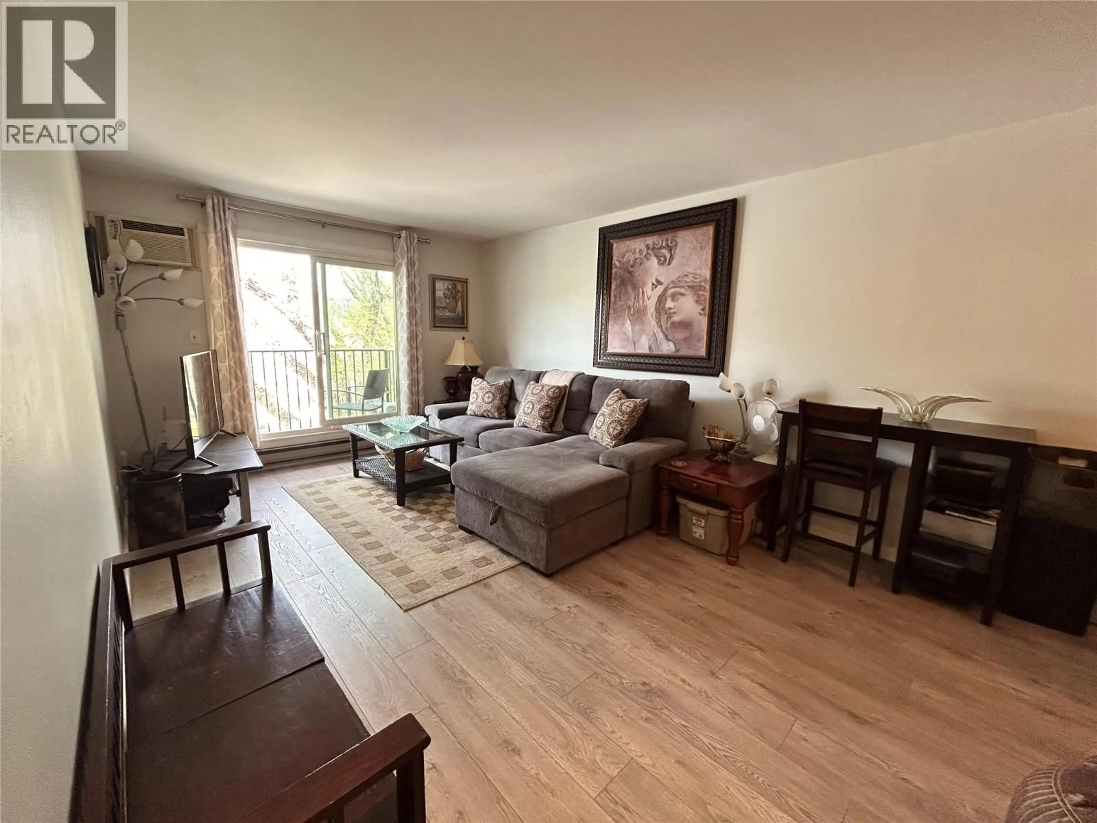 Living room with furniture, wood/laminate floor for 208 - 922 DYNES AVENUE, Penticton British Columbia V2A1E8
