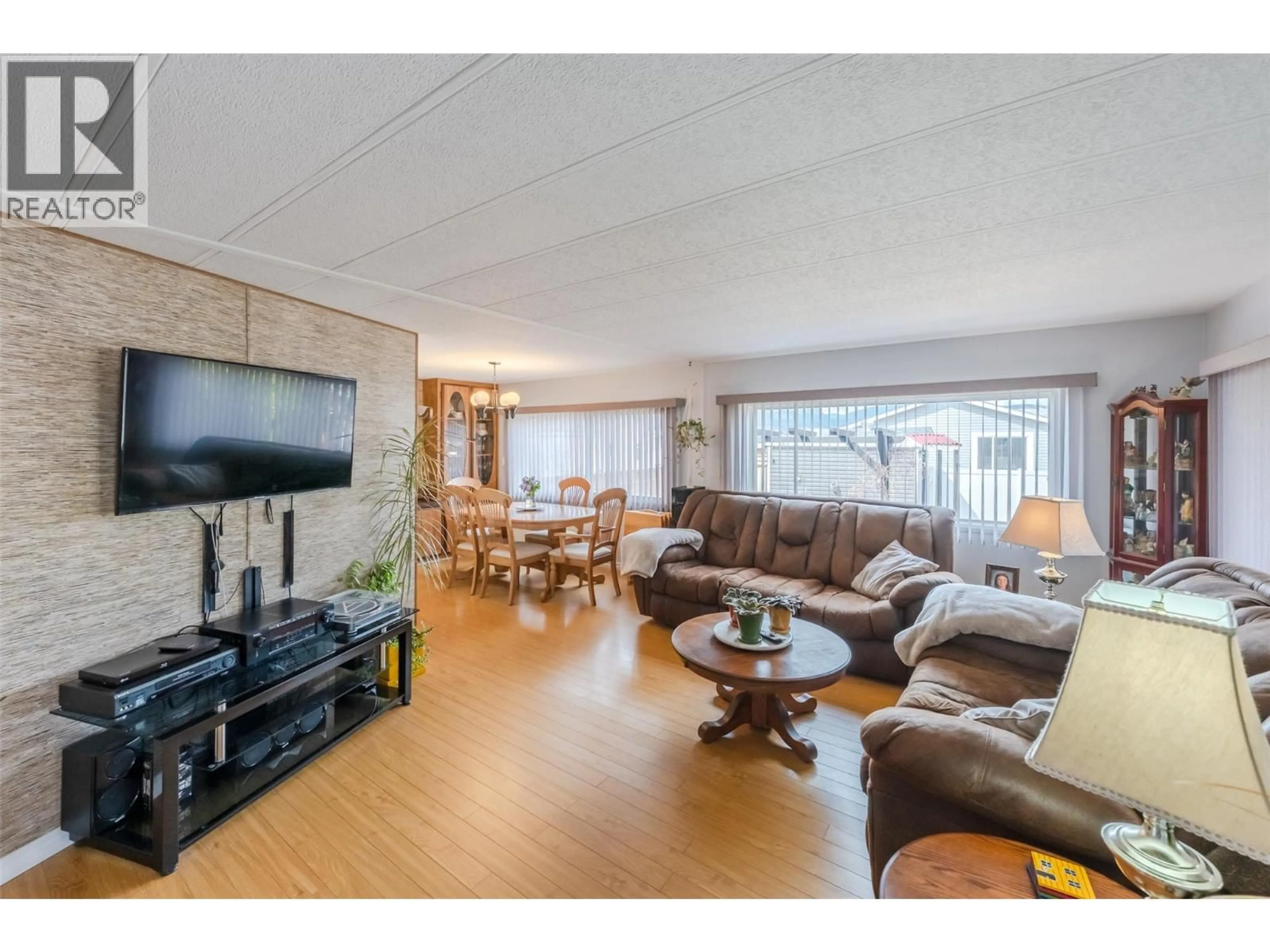 Living room with furniture, wood/laminate floor for 30 - 6601 TUCELNUIT DRIVE, Oliver British Columbia V0H1T3