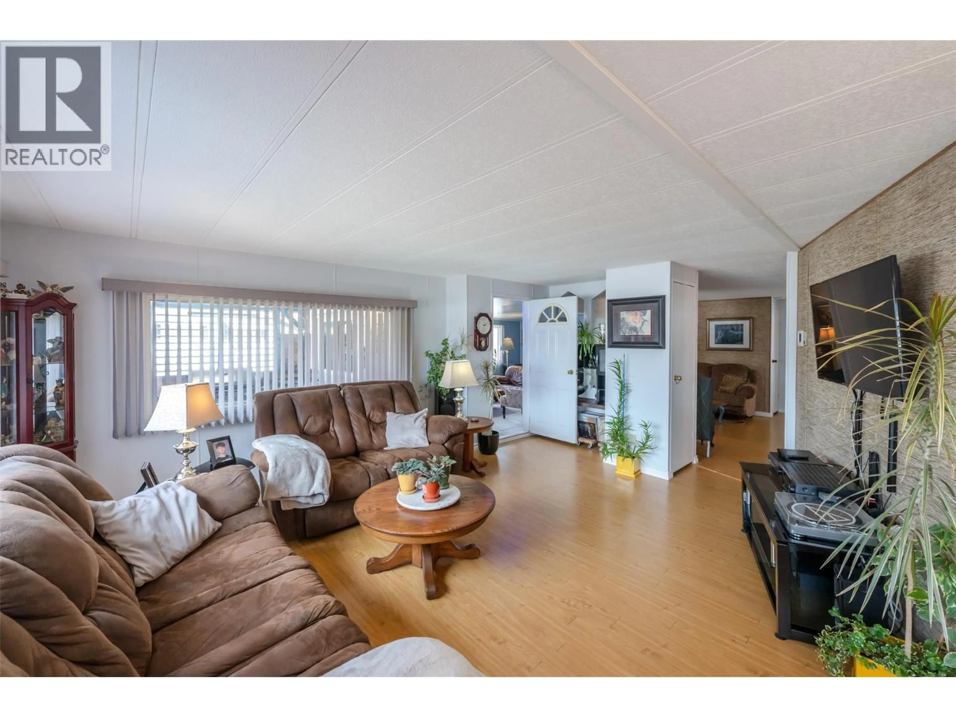 Living room with furniture, wood/laminate floor for 30 - 6601 TUCELNUIT DRIVE, Oliver British Columbia V0H1T3