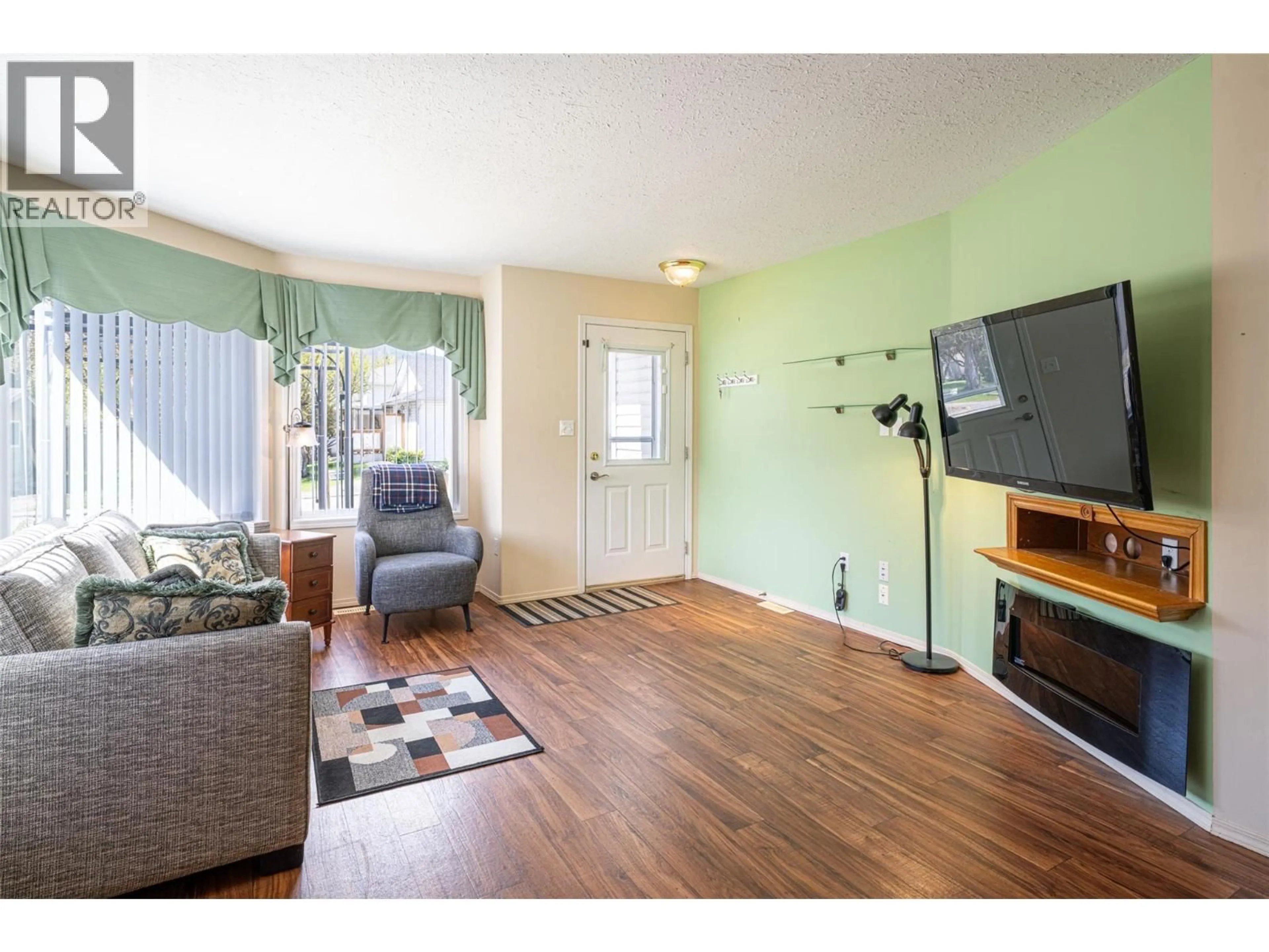 Living room with furniture, wood/laminate floor for 1 - 2716 WOLFENDEN TERRACE, Armstrong British Columbia V4Y2A6