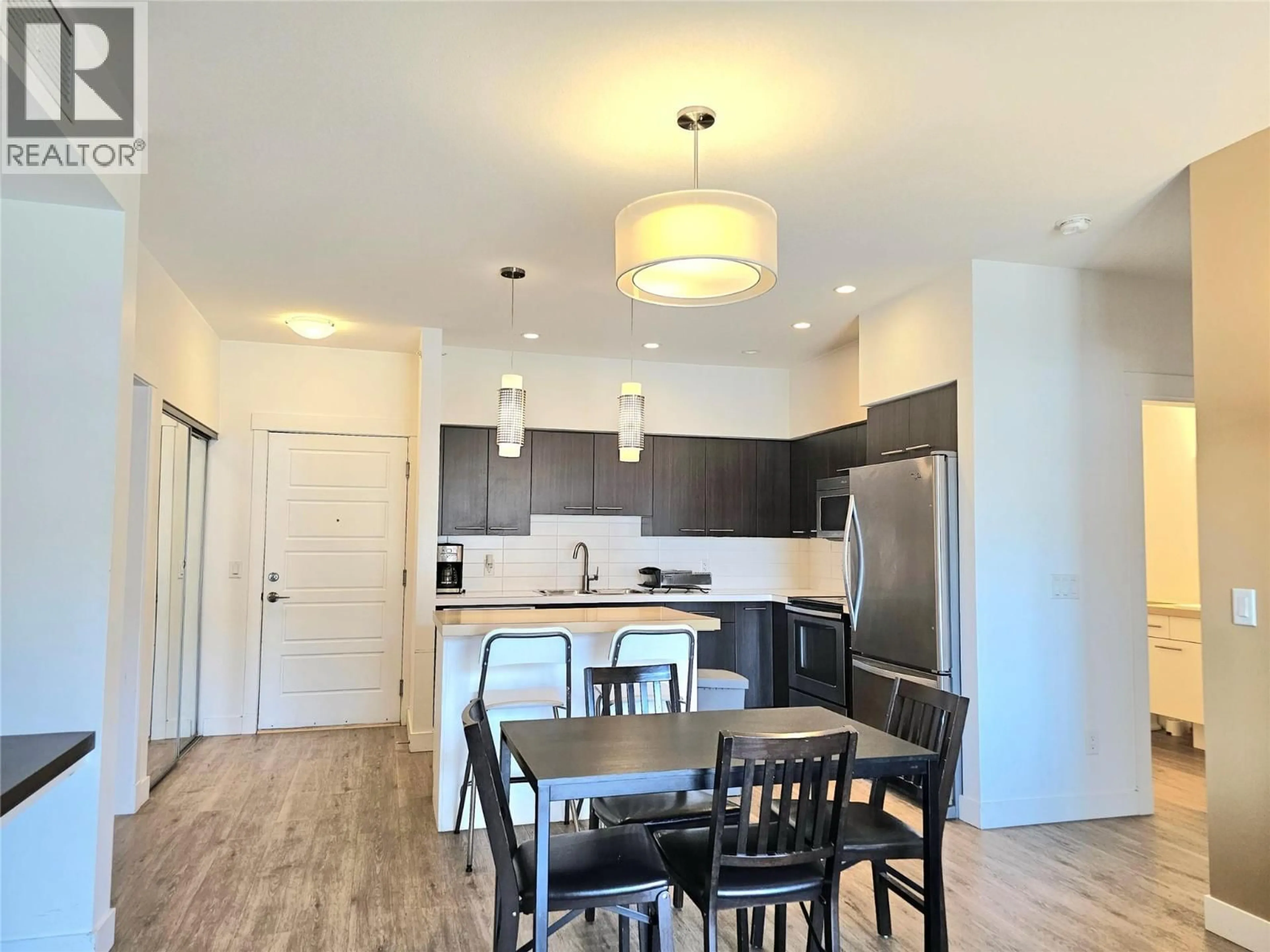Open concept kitchen, wood/laminate floor for 310 - 985 ACADEMY WAY, Kelowna British Columbia V1V3C8