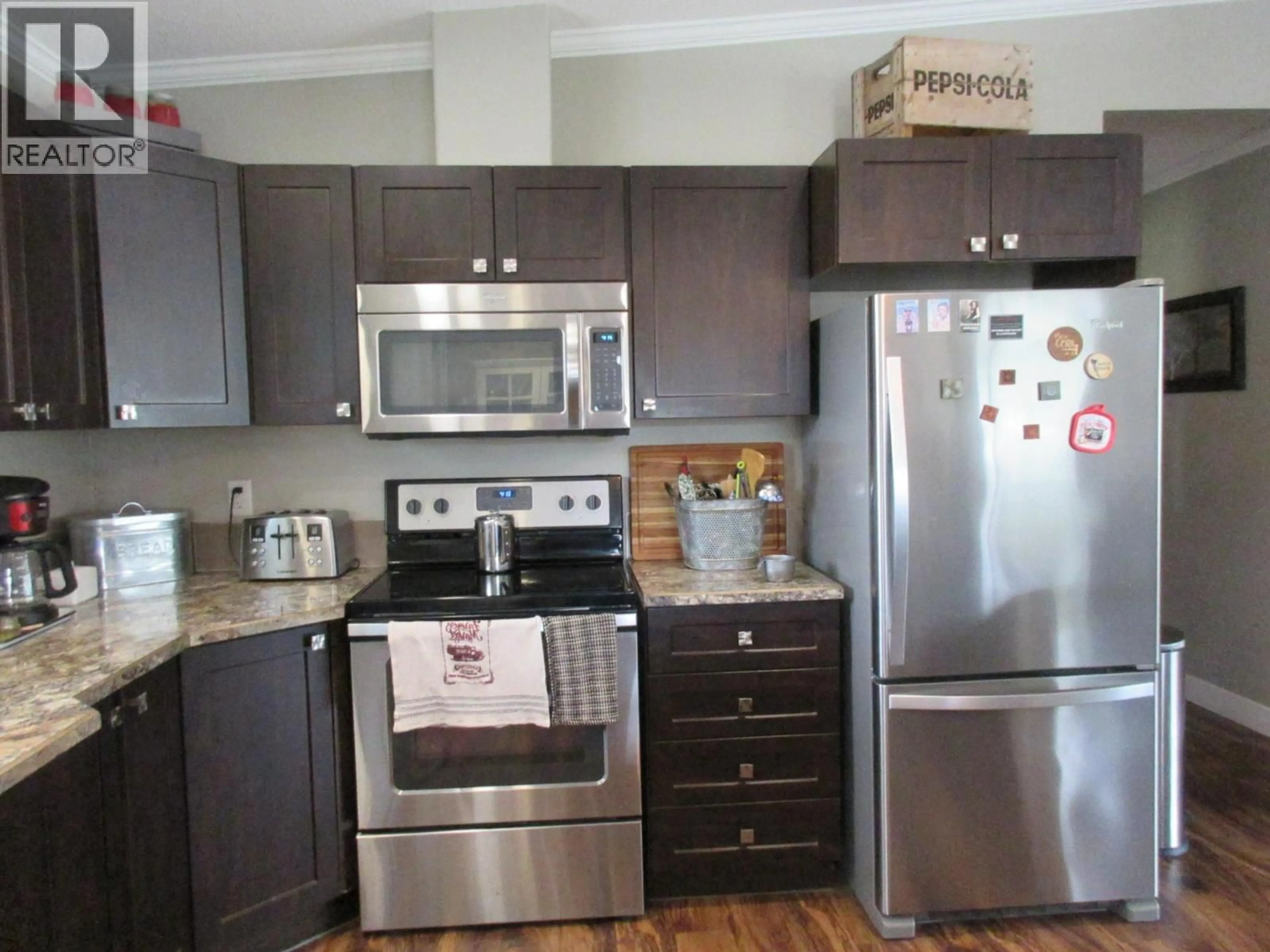 Open concept kitchen, wood/laminate floor for 2544 CORKLE STREET, Merritt British Columbia V0K1Y0