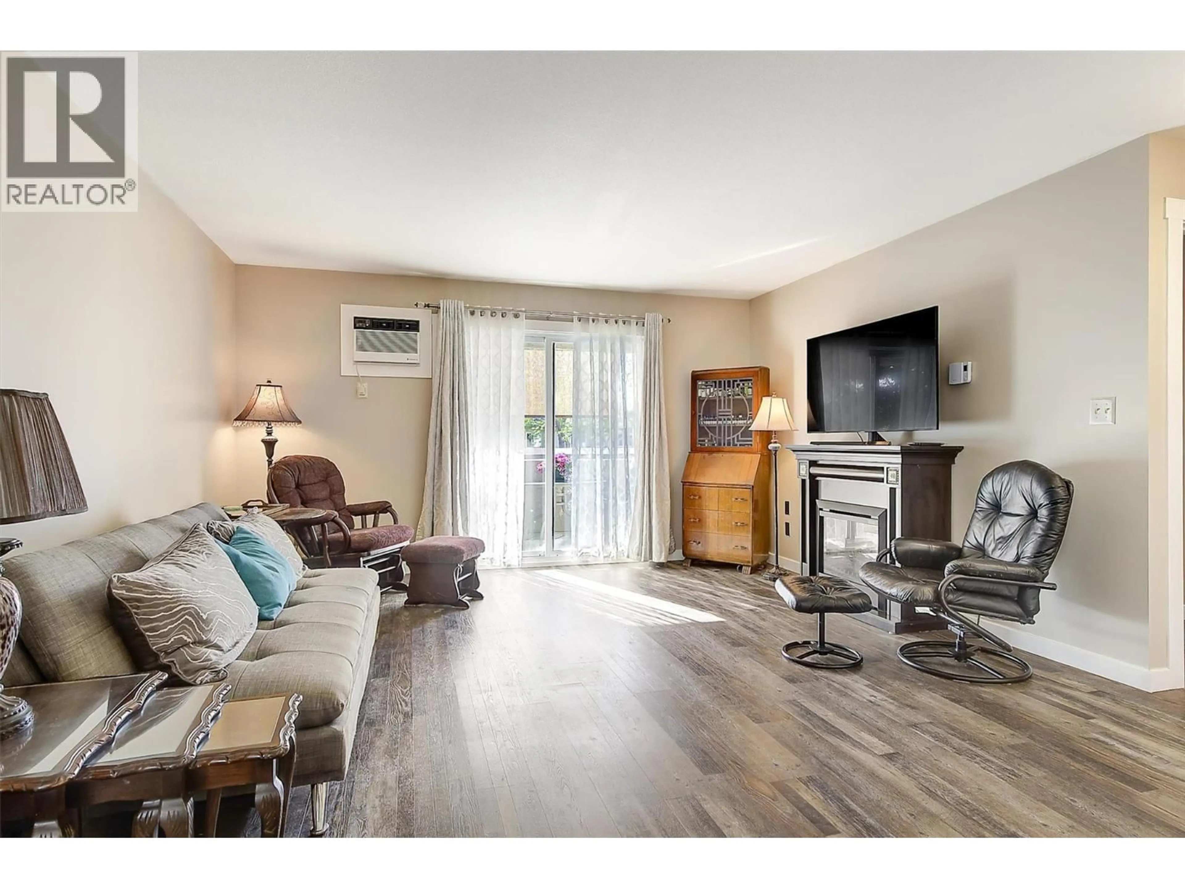 Living room with furniture, wood/laminate floor for 216 - 3842 GORDON DRIVE, Kelowna British Columbia V1W3G4