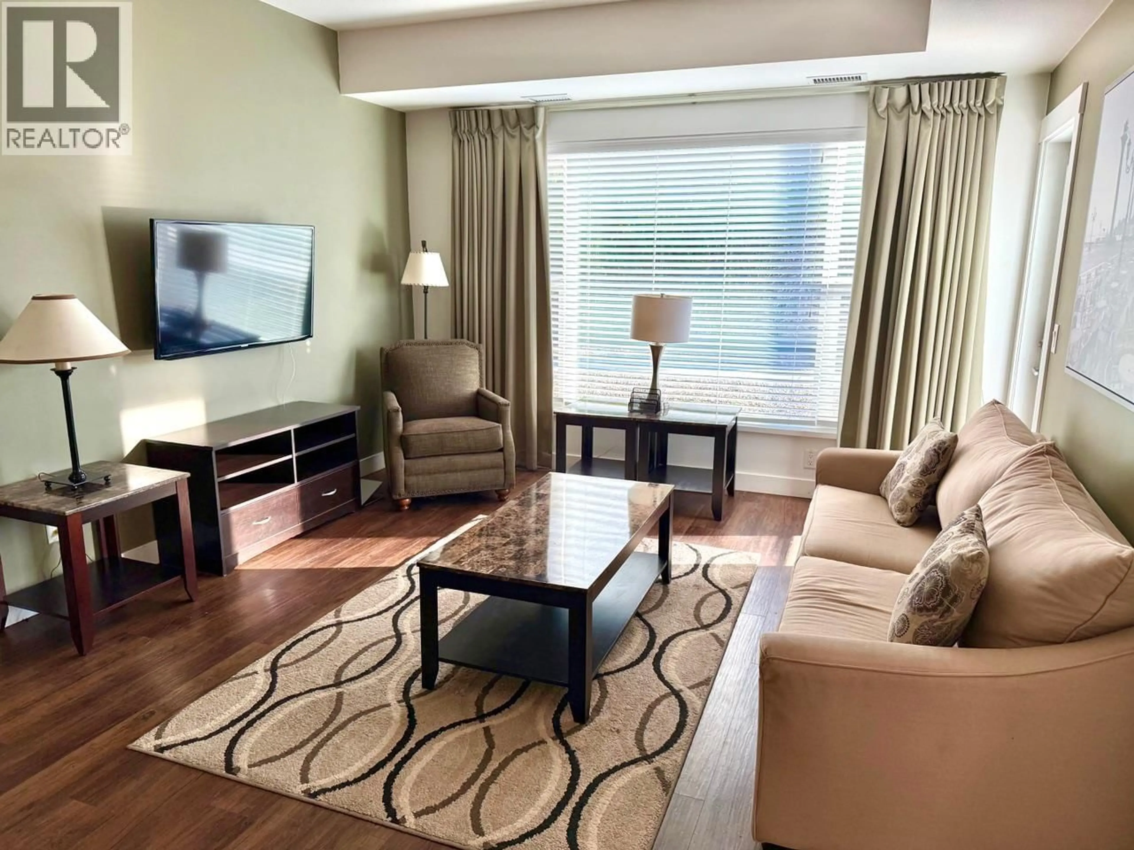 Living room with furniture, wood/laminate floor for 216 - 975 ACADEMY WAY, Kelowna British Columbia V1V3C8