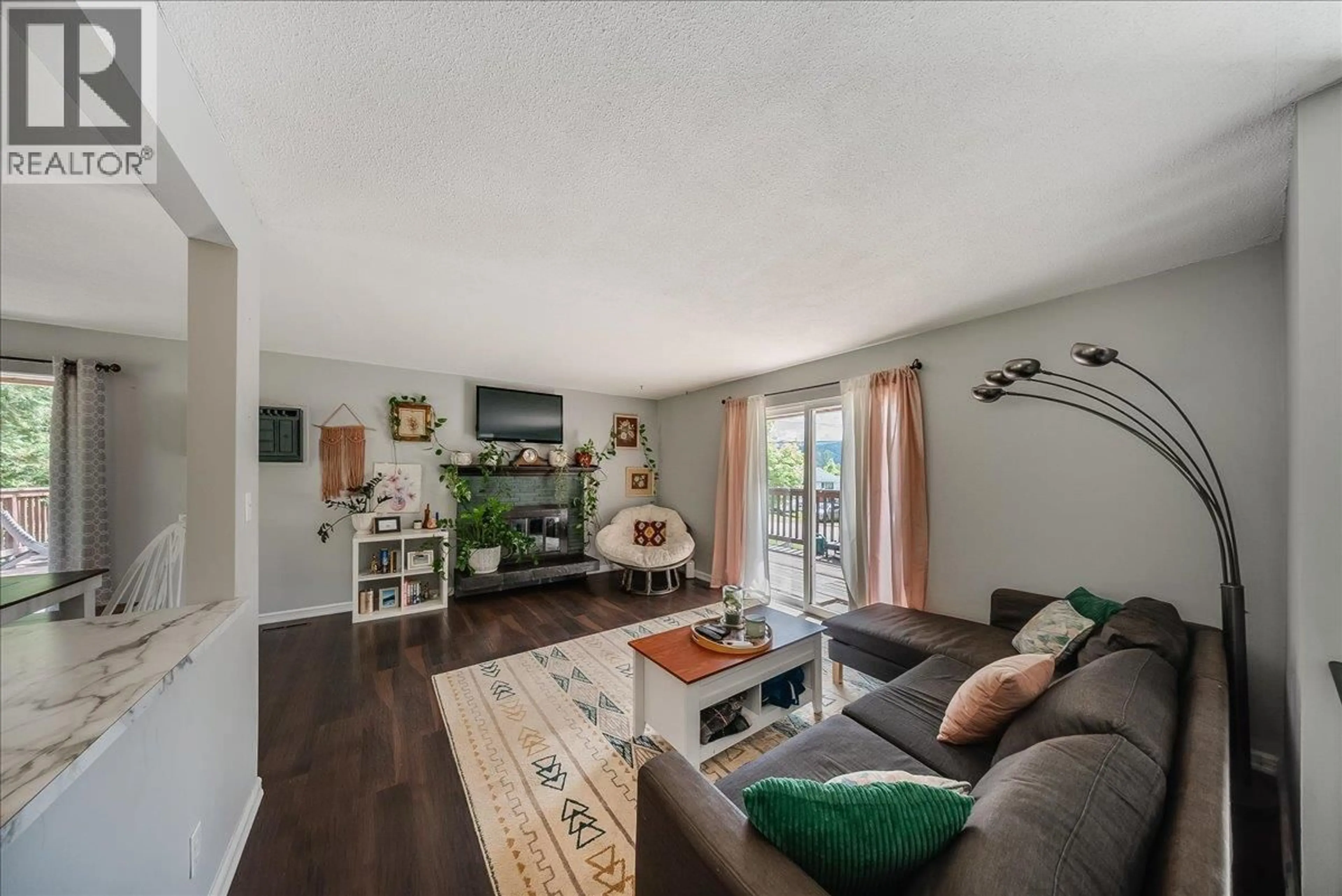 Living room with furniture, wood/laminate floor for 1106 CLARKE ROAD, Robson British Columbia V0G1X0