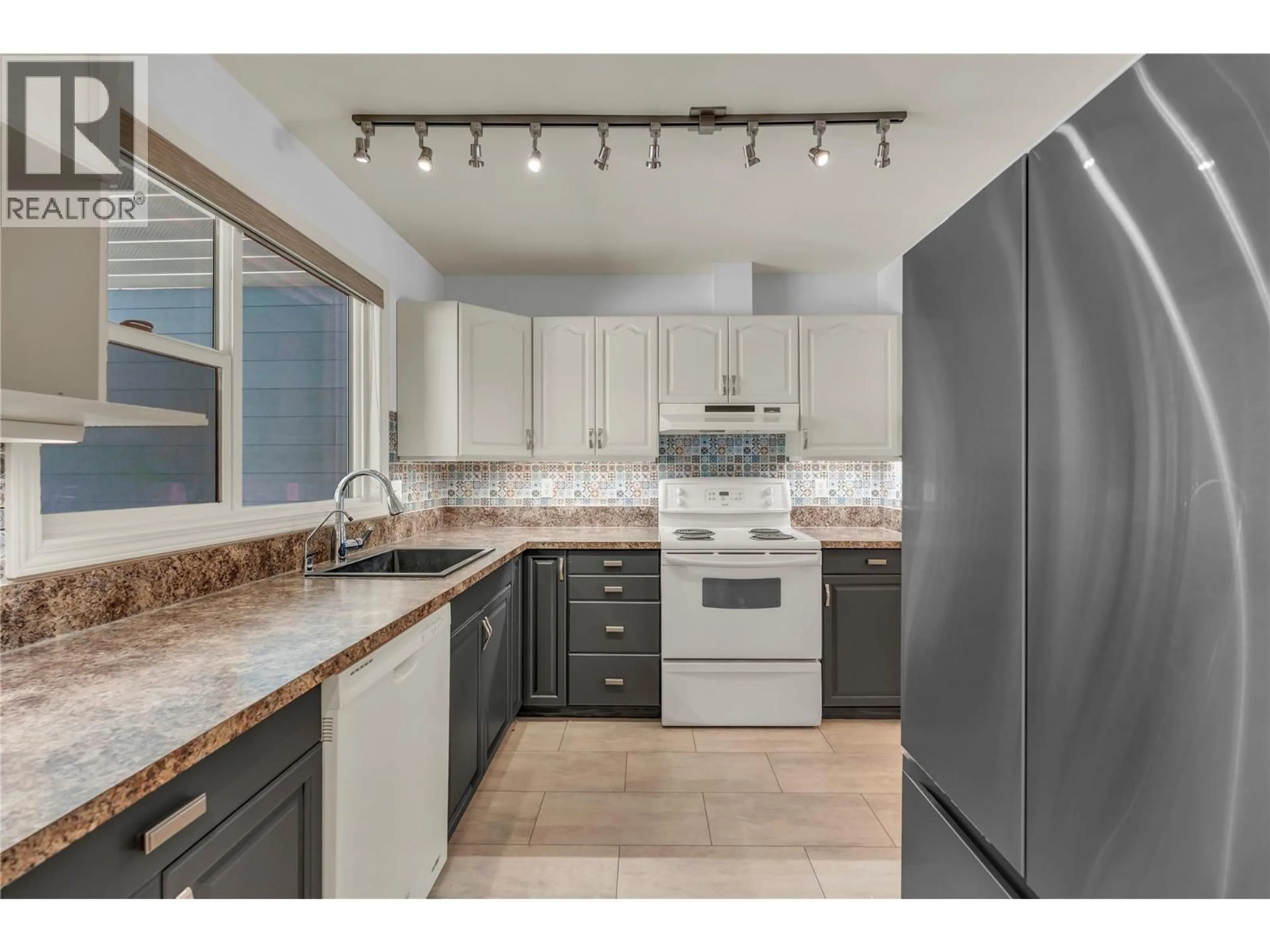 Open concept kitchen, ceramic/tile floor for 104 - 7717 PRAIRIE VALLEY ROAD, Summerland British Columbia V0H1Z4
