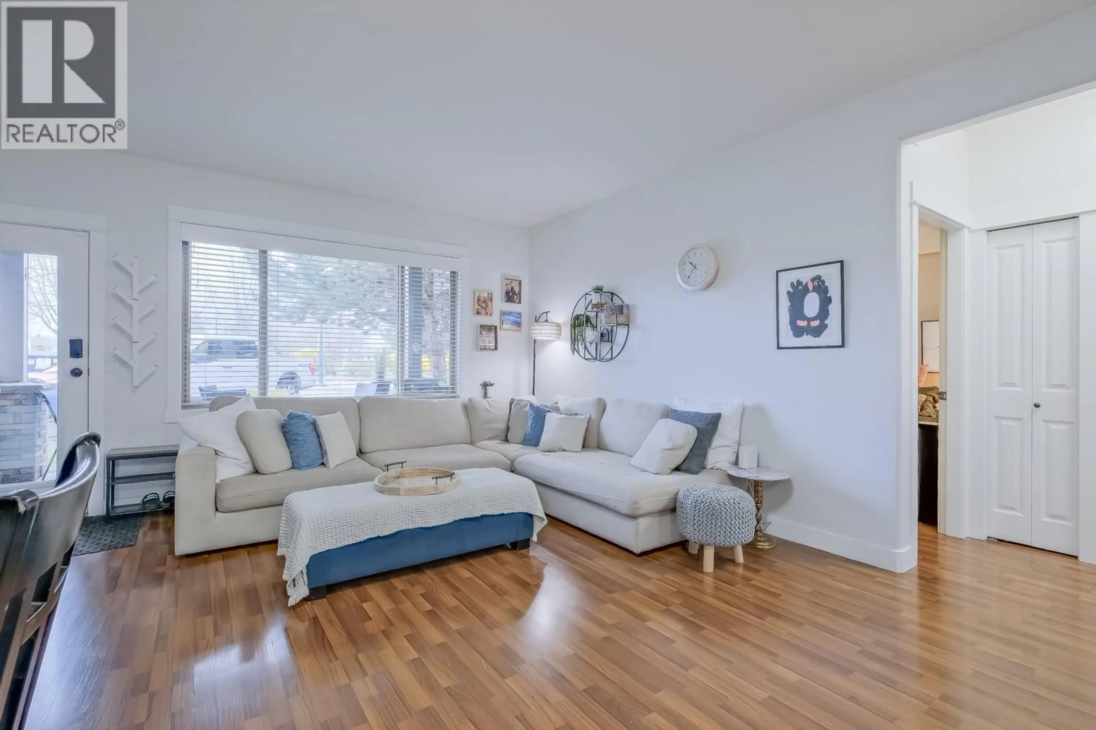 Living room with furniture, wood/laminate floor for 202 - 3350 WOODSDALE ROAD, Lake Country British Columbia V4V2R7