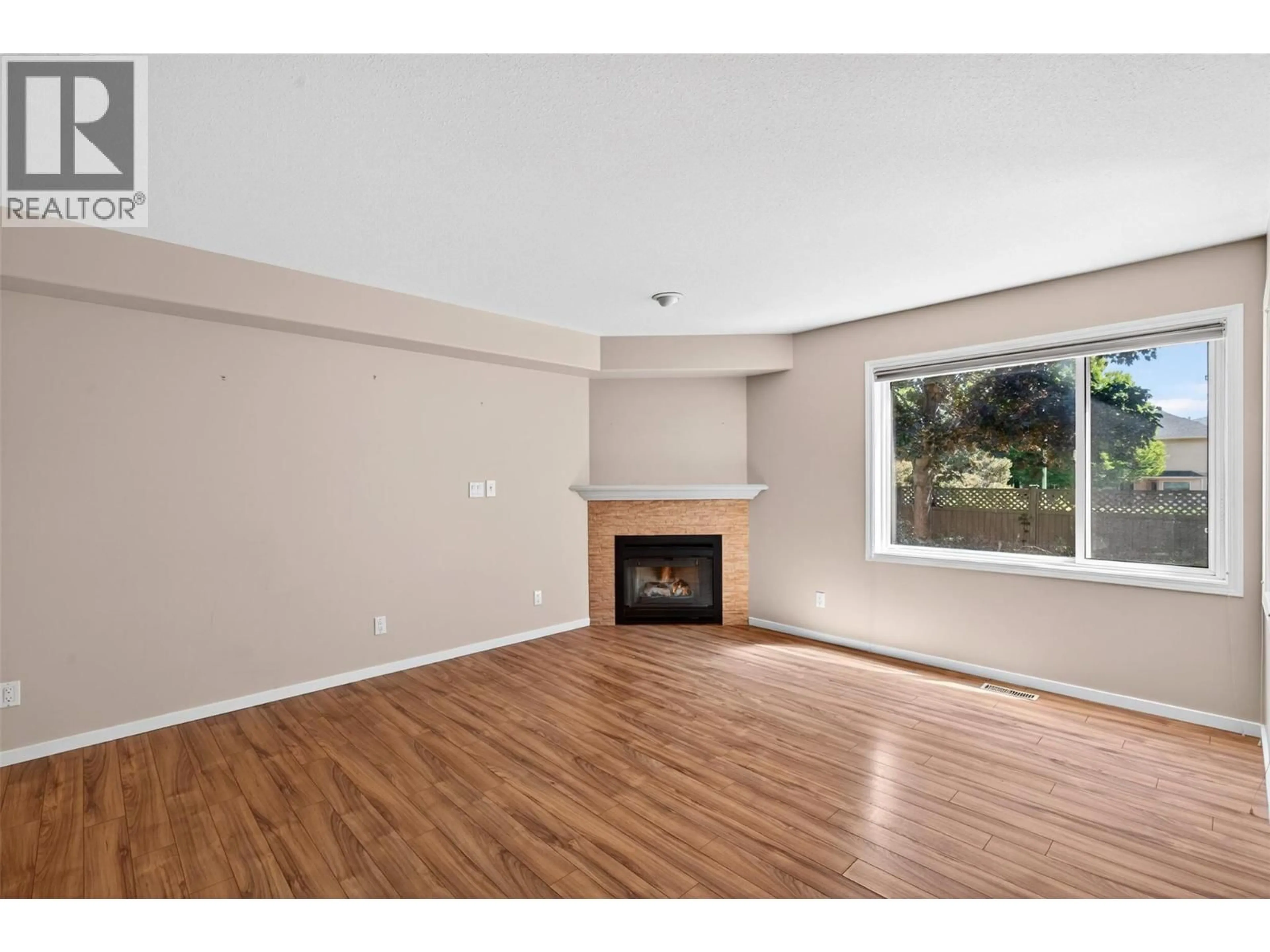 Living room with furniture, wood/laminate floor for 106 - 321 WHITMAN ROAD, Kelowna British Columbia V1V1Y6