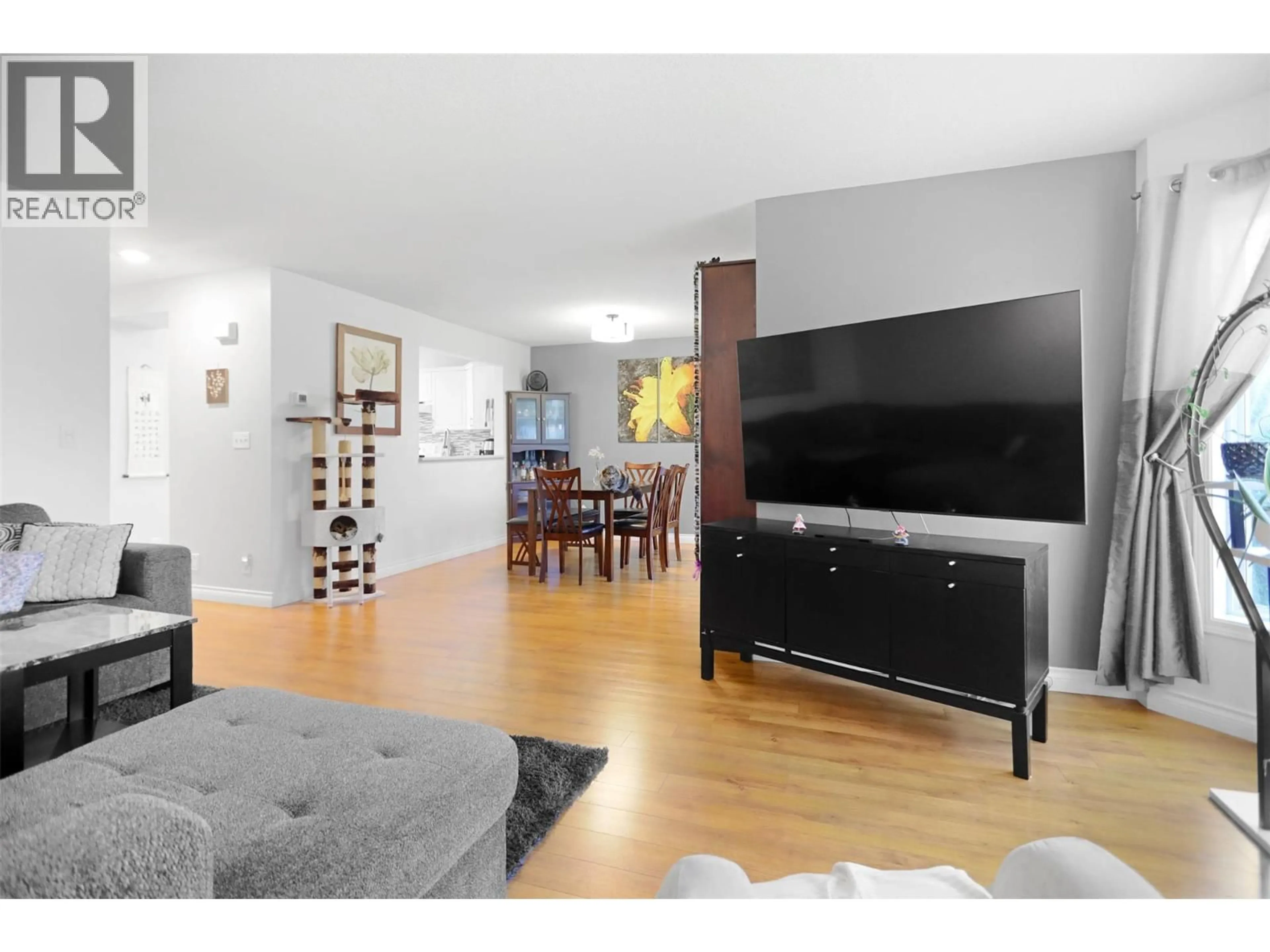 Living room with furniture, wood/laminate floor for 109 - 1120 GUISACHAN ROAD, Kelowna British Columbia V1Y9R5