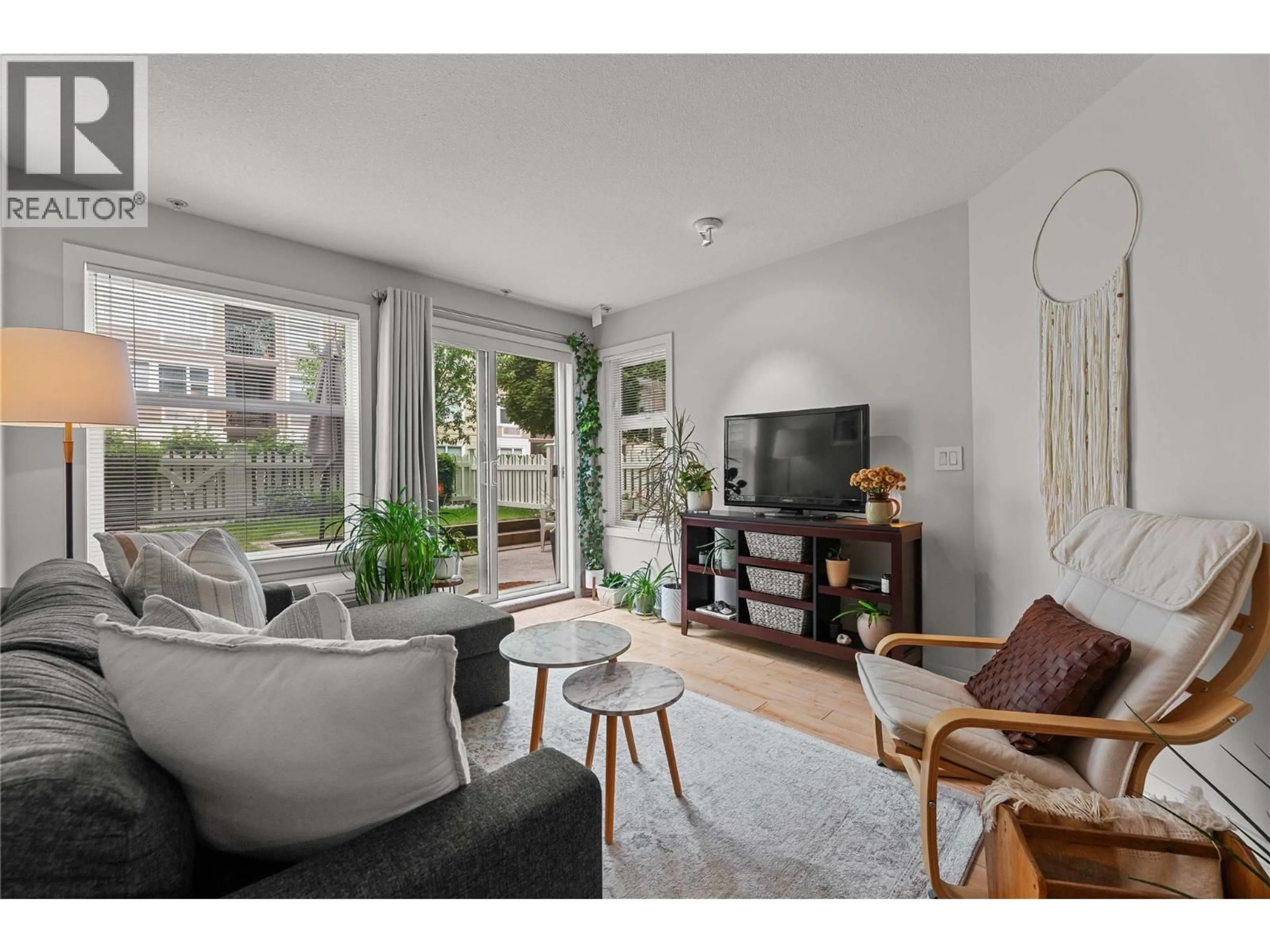 Living room with furniture, wood/laminate floor for 107 - 539 YATES ROAD, Kelowna British Columbia V1V2T8