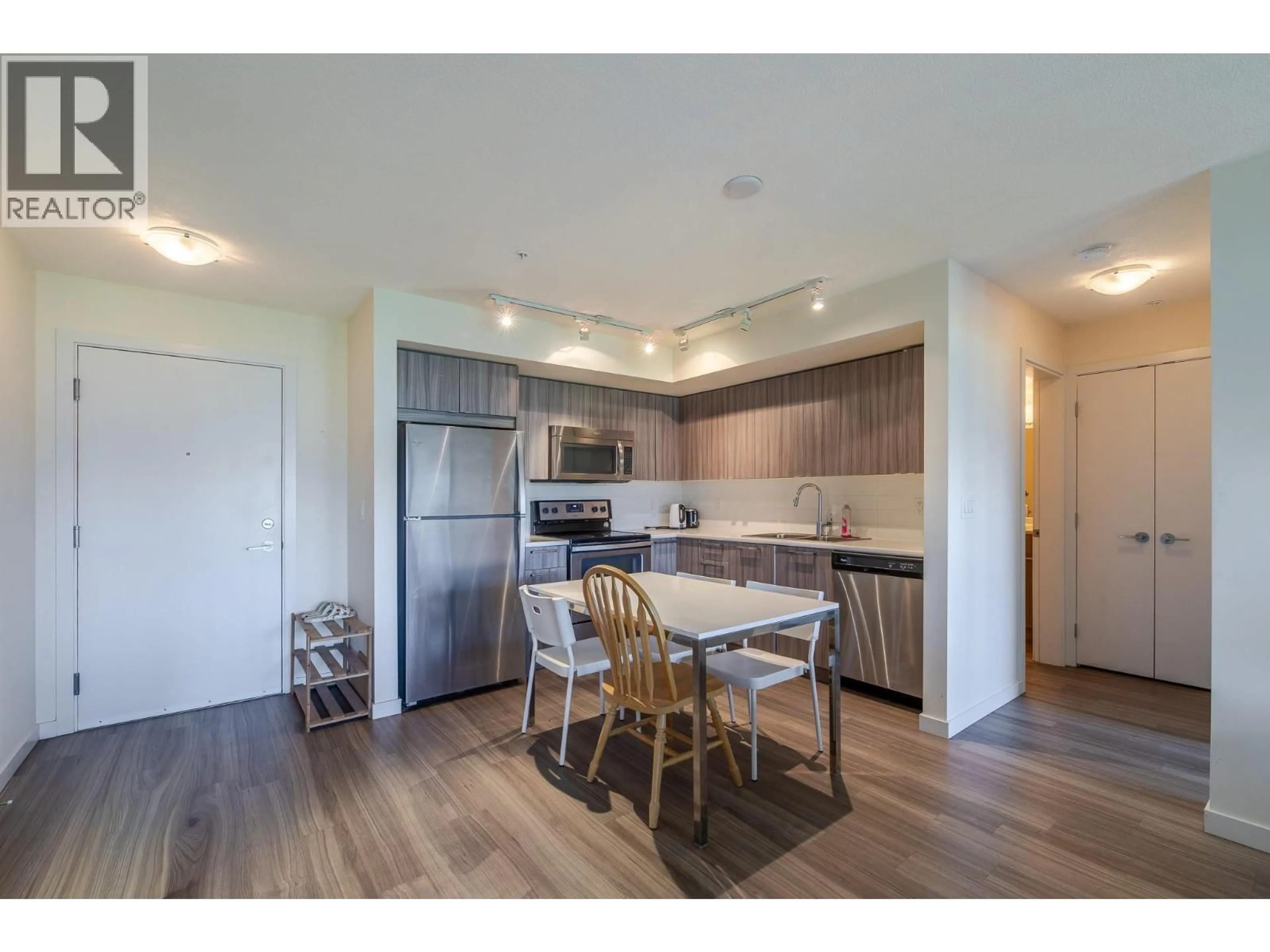 Open concept kitchen, wood/laminate floor for 202 - 883 ACADEMY WAY, Kelowna British Columbia V1V0A3