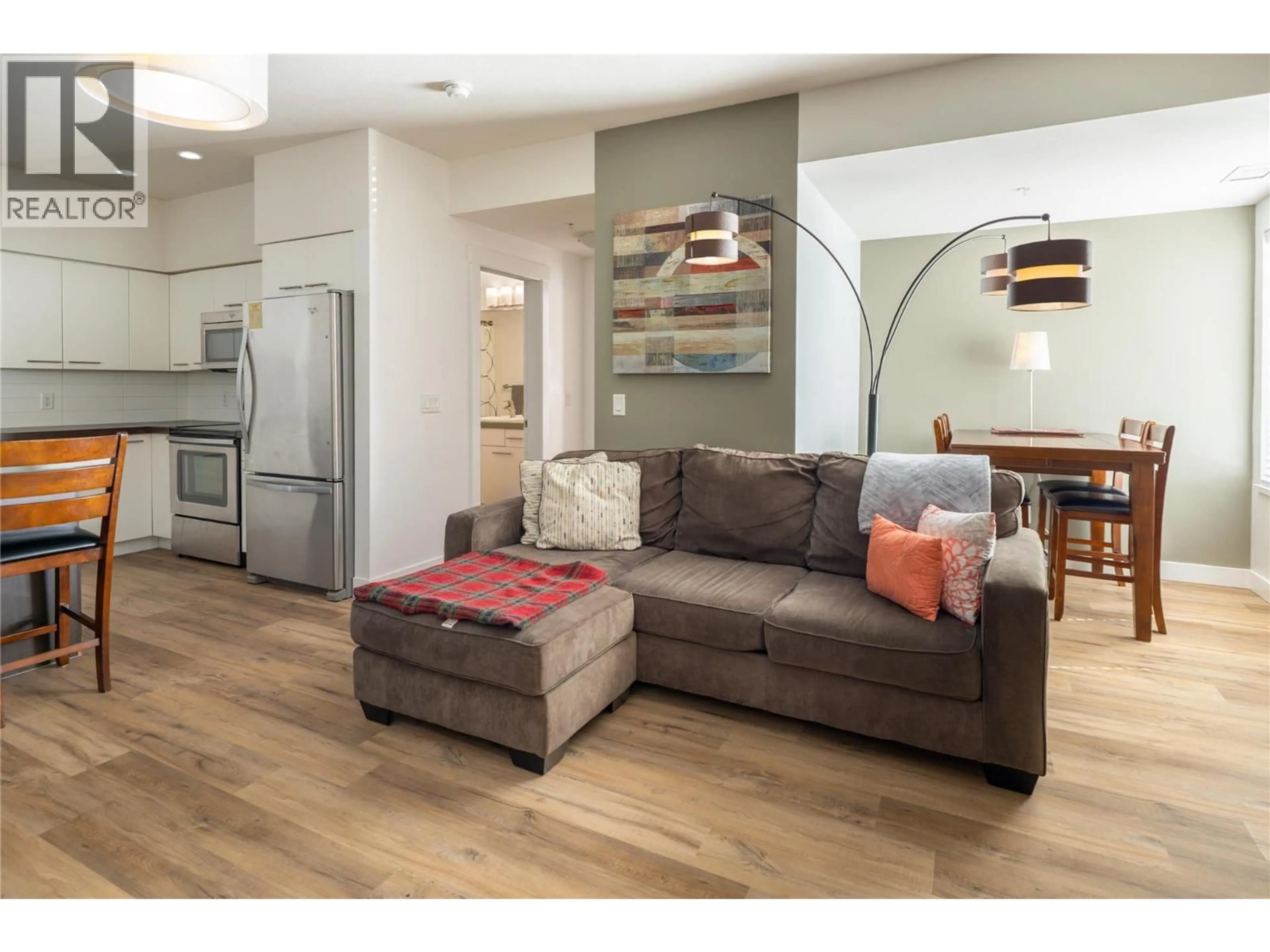 Living room with furniture, wood/laminate floor for 208 - 985 ACADEMY WAY, Kelowna British Columbia V1V3C8