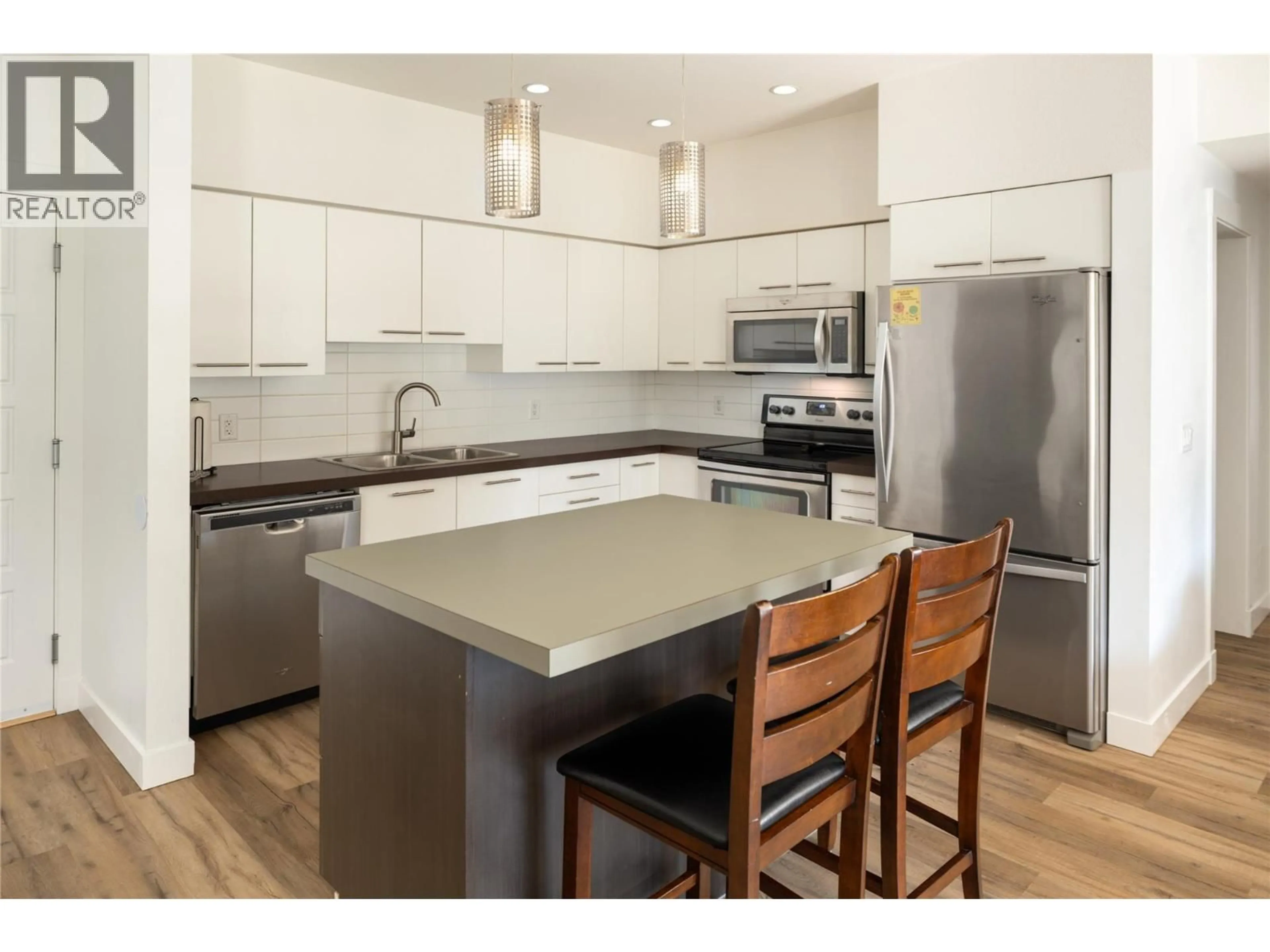 Open concept kitchen, wood/laminate floor for 208 - 985 ACADEMY WAY, Kelowna British Columbia V1V3C8