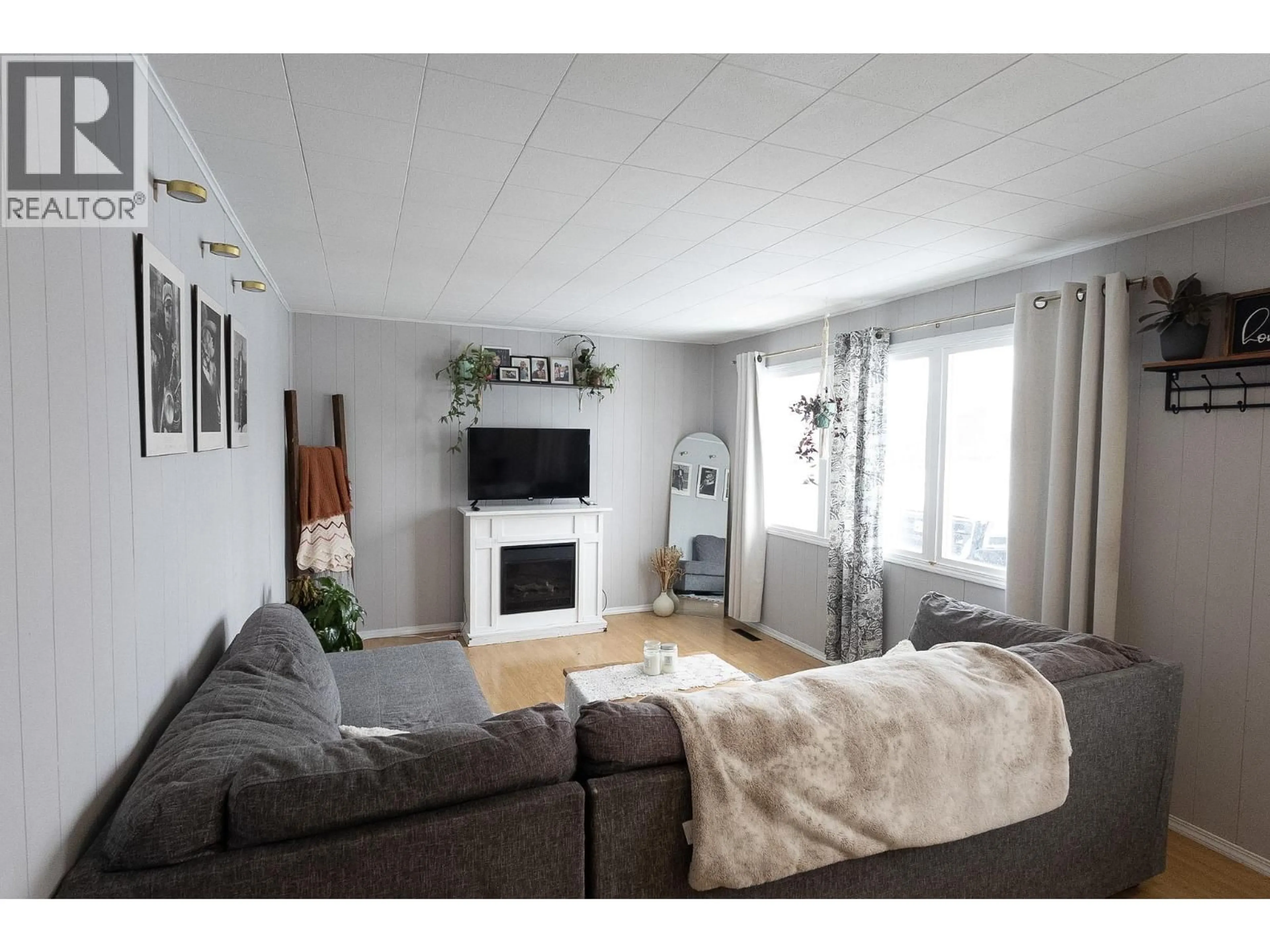 Living room with furniture, wood/laminate floor for 1016 120 AVENUE, Dawson Creek British Columbia V1G3J7