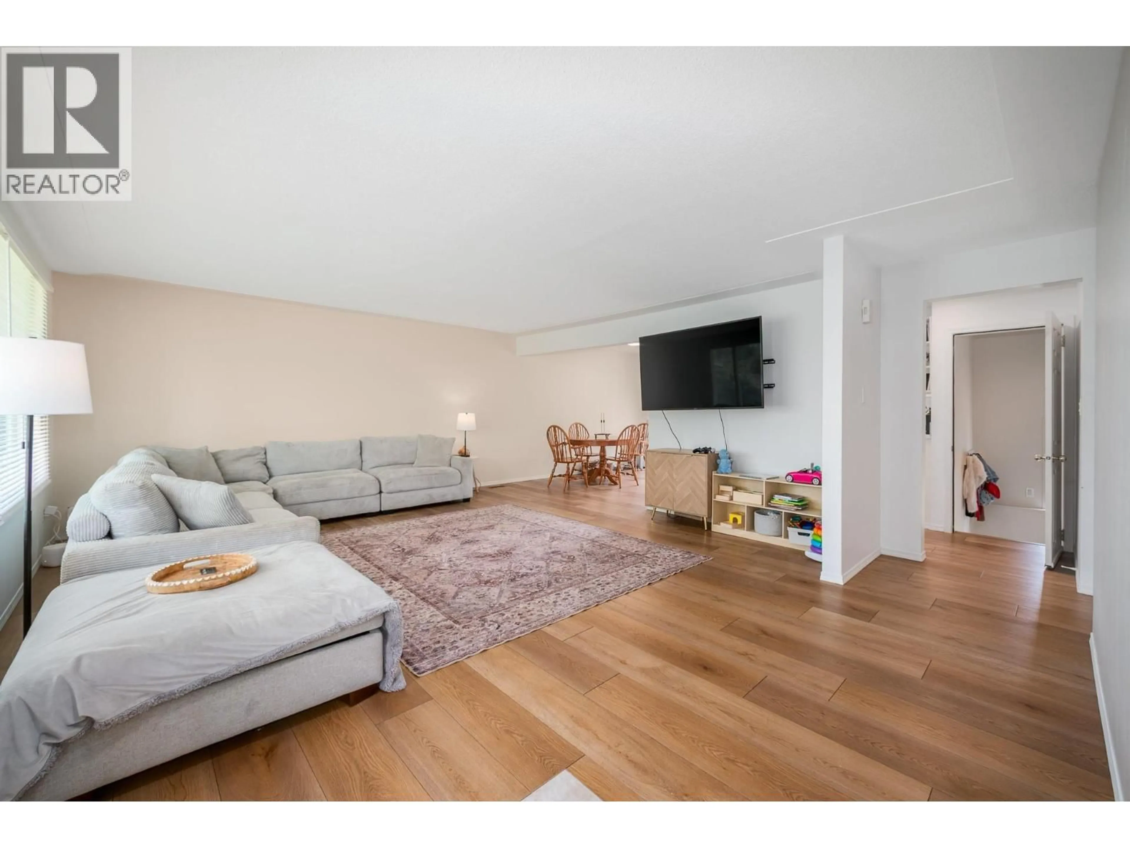 Living room with furniture, wood/laminate floor for 679 MCCLURE ROAD, Kelowna British Columbia V1W1L7