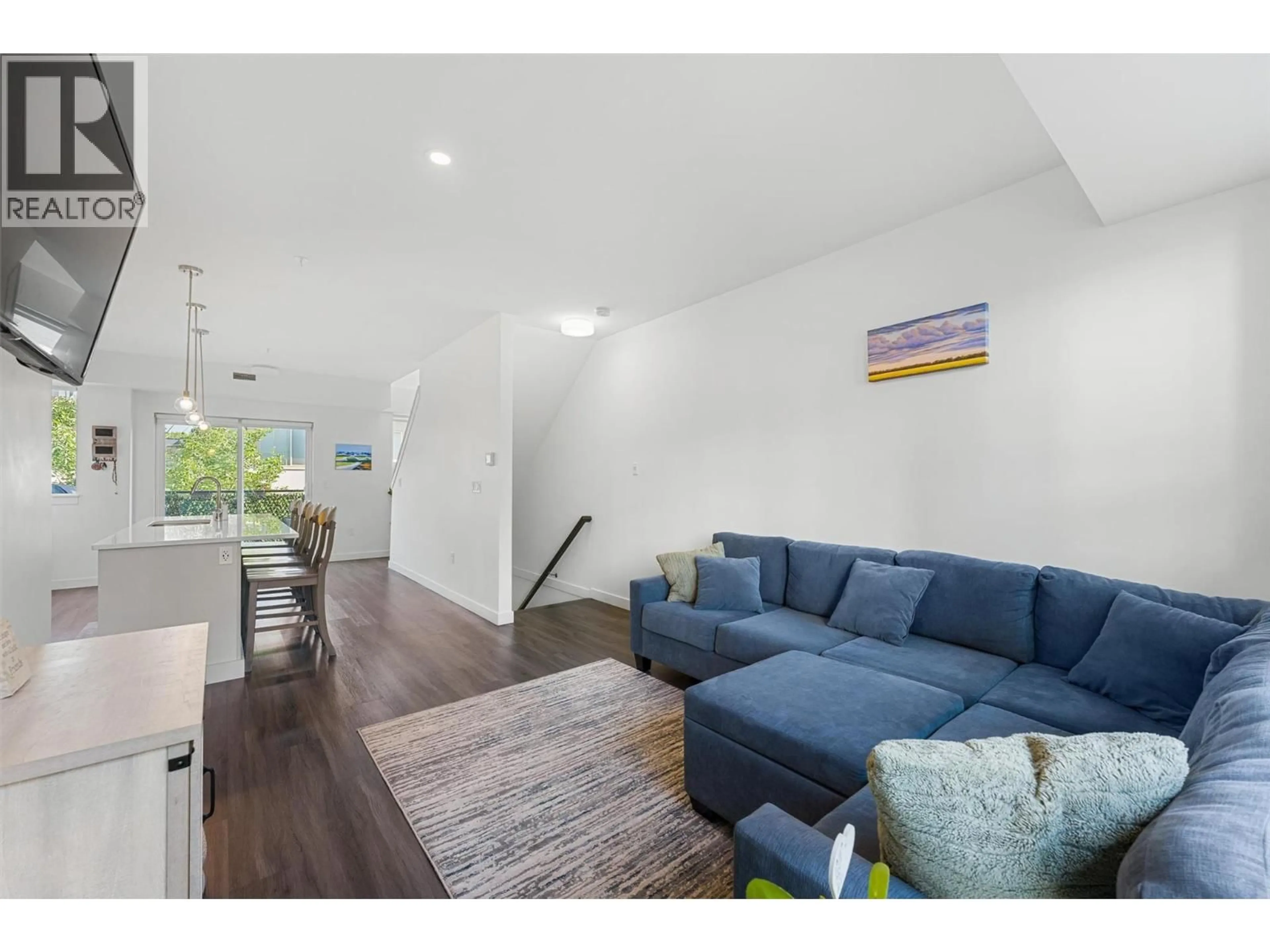 Living room with furniture, wood/laminate floor for 103 - 3630 MISSION SPRINGS DRIVE, Kelowna British Columbia V1W0B2