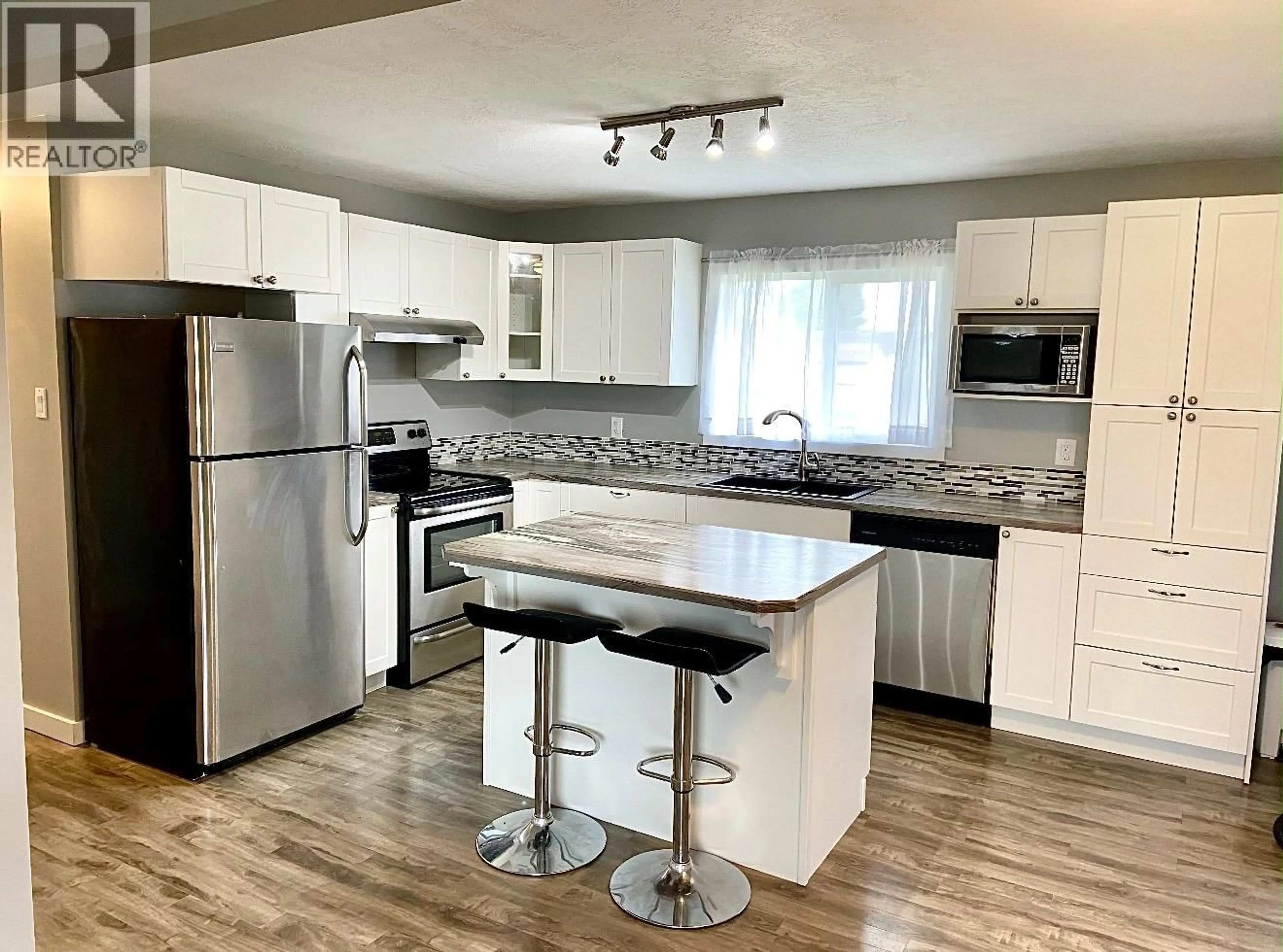 Open concept kitchen, wood/laminate floor for 1312 116 AVENUE, Dawson Creek British Columbia V1G3E7