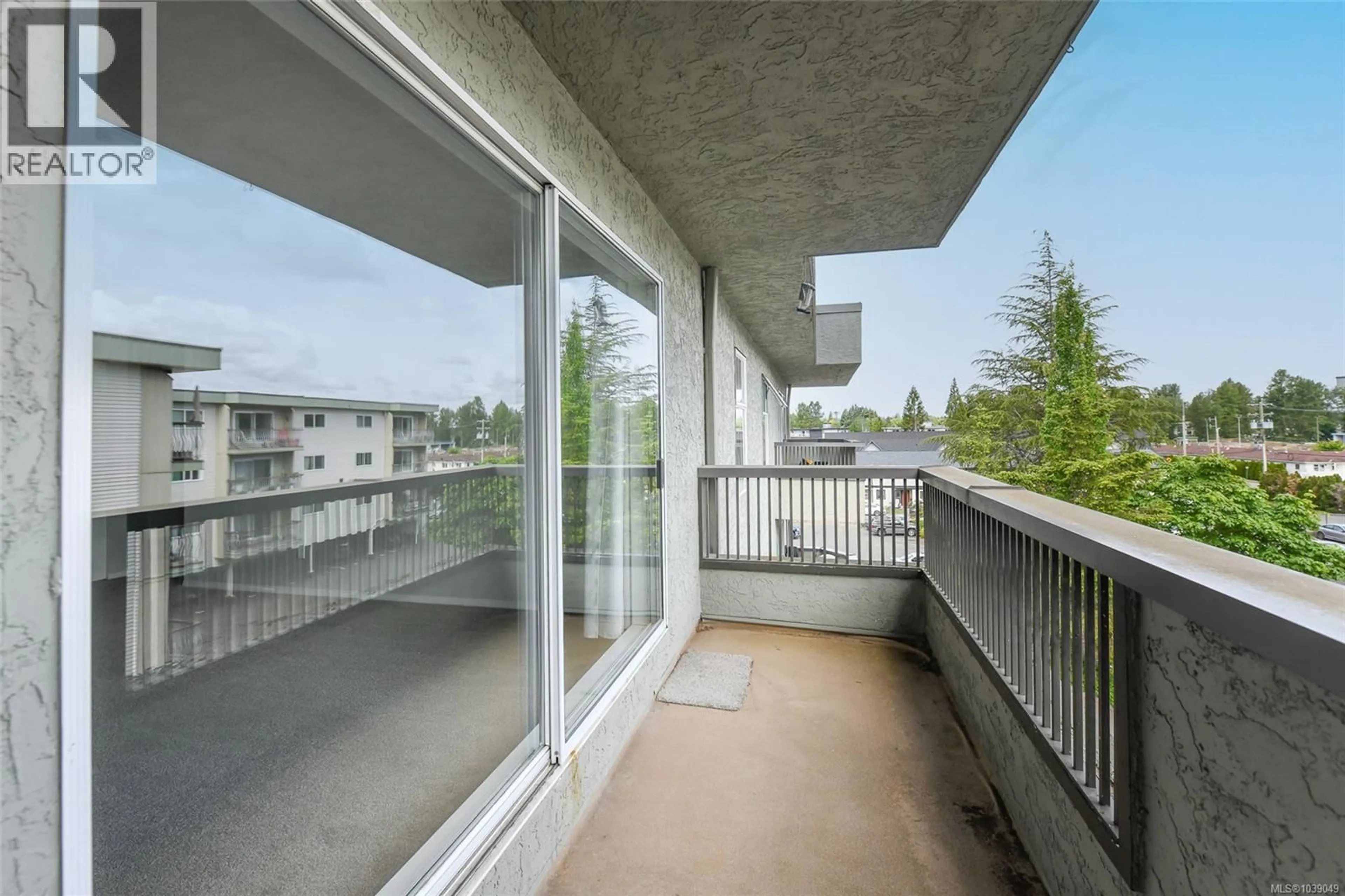 Balcony in the apartment, city buildings view from balcony for 409 - 1045 CUMBERLAND ROAD, Courtenay British Columbia V9N2E7