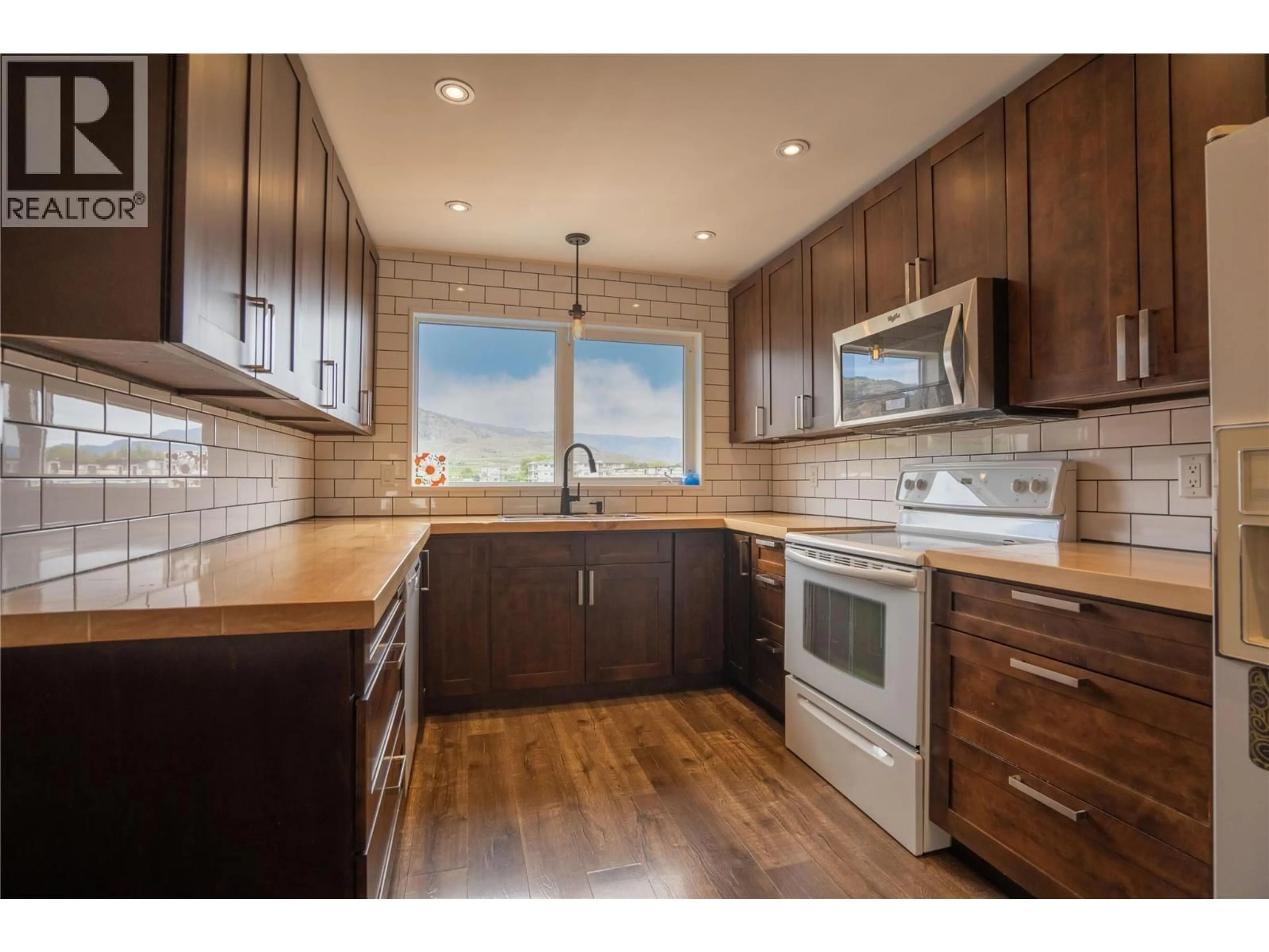 Open concept kitchen, wood/laminate floor for 13 HEATHER PLACE, Osoyoos British Columbia V0H1V1