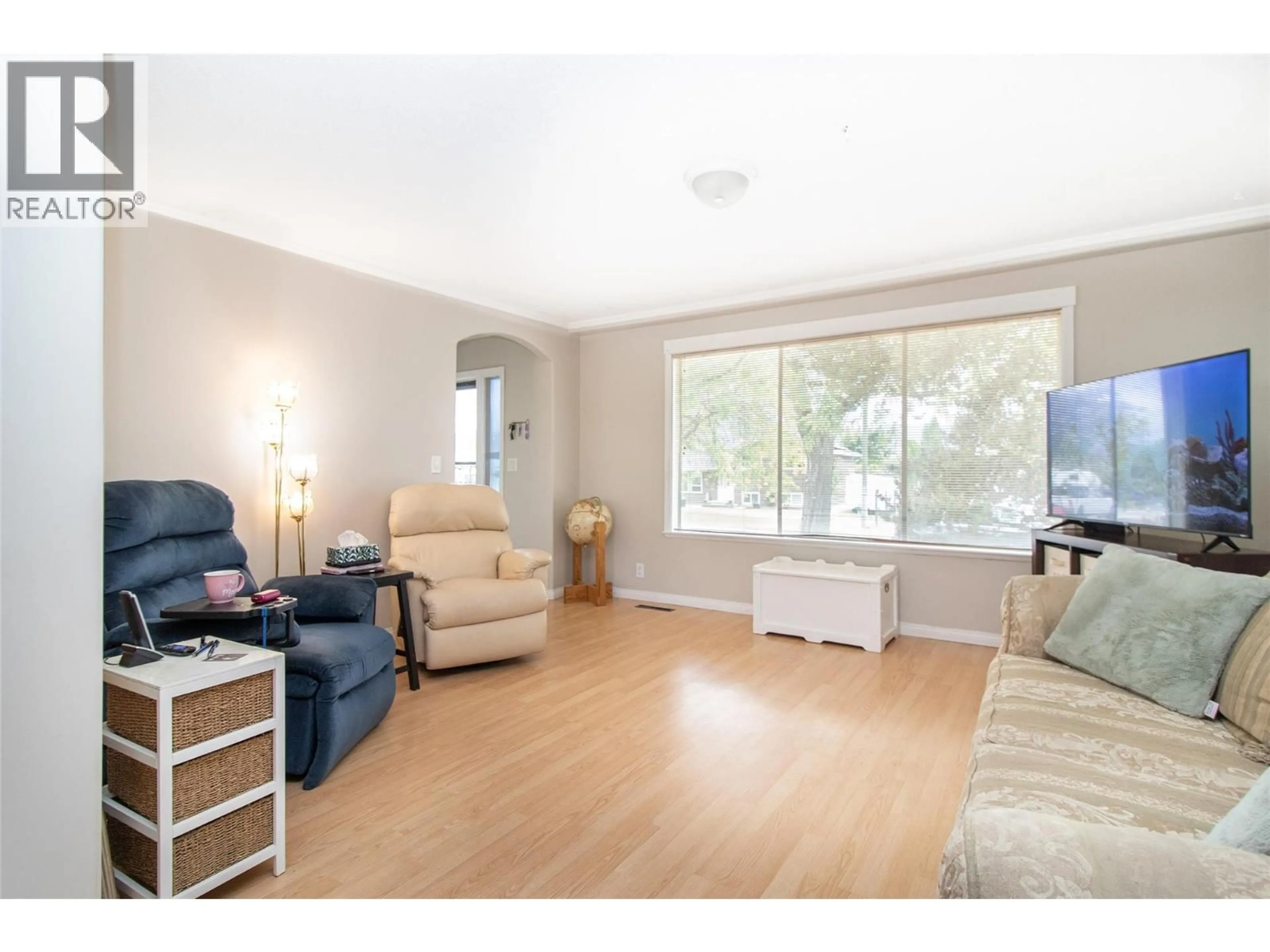 Living room with furniture, wood/laminate floor for 1381 MCBRIDE ROAD, Kelowna British Columbia V1Y4A5