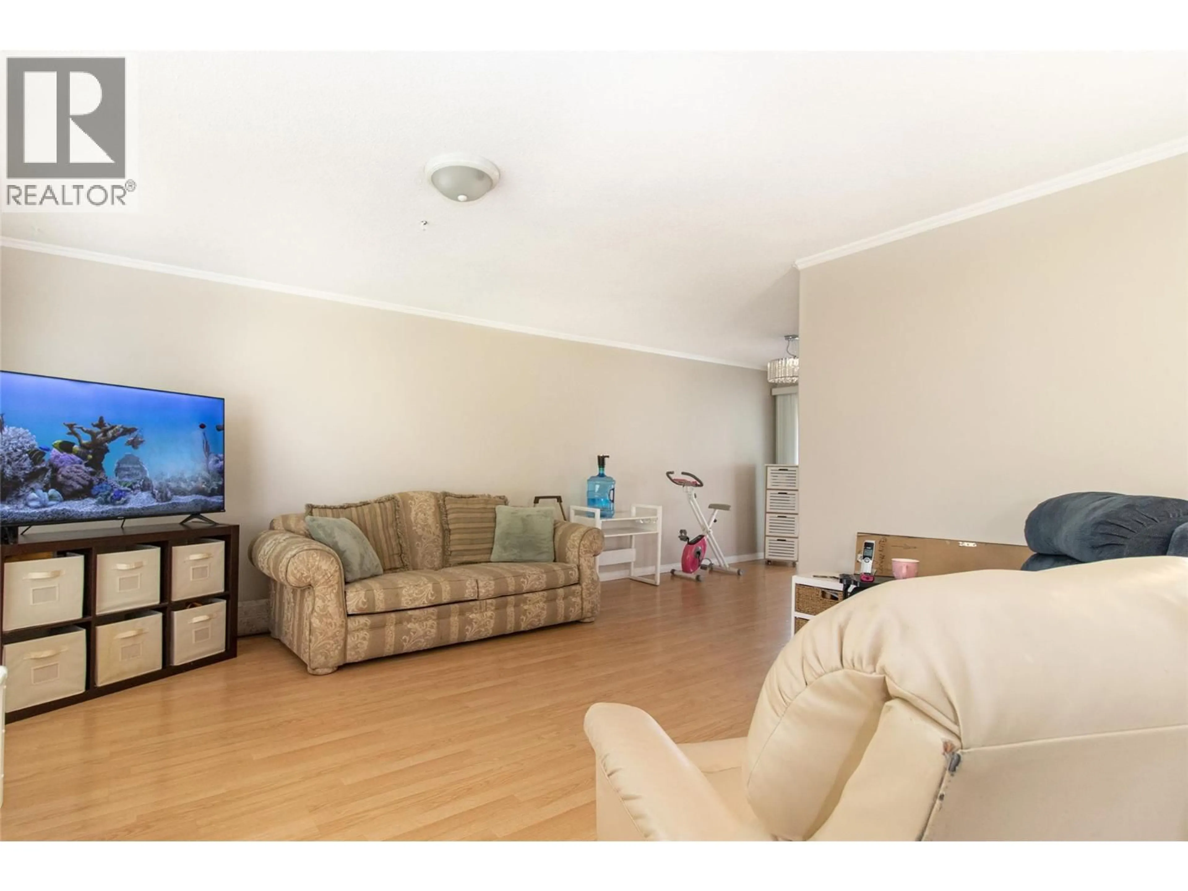 Living room with furniture, wood/laminate floor for 1381 MCBRIDE ROAD, Kelowna British Columbia V1Y4A5