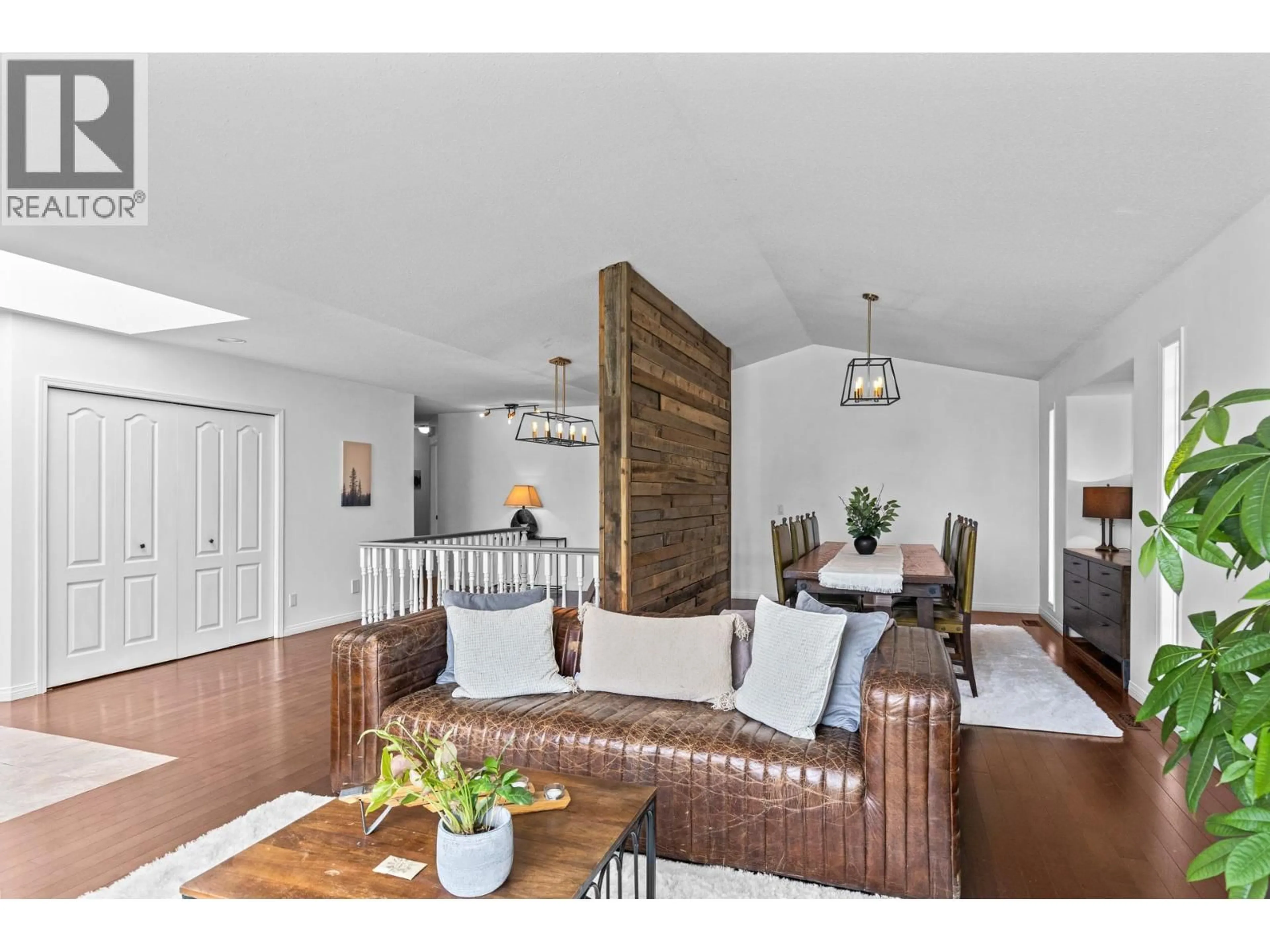Living room with furniture, wood/laminate floor for 145 MAGIC DRIVE, Kelowna British Columbia V1V1N2