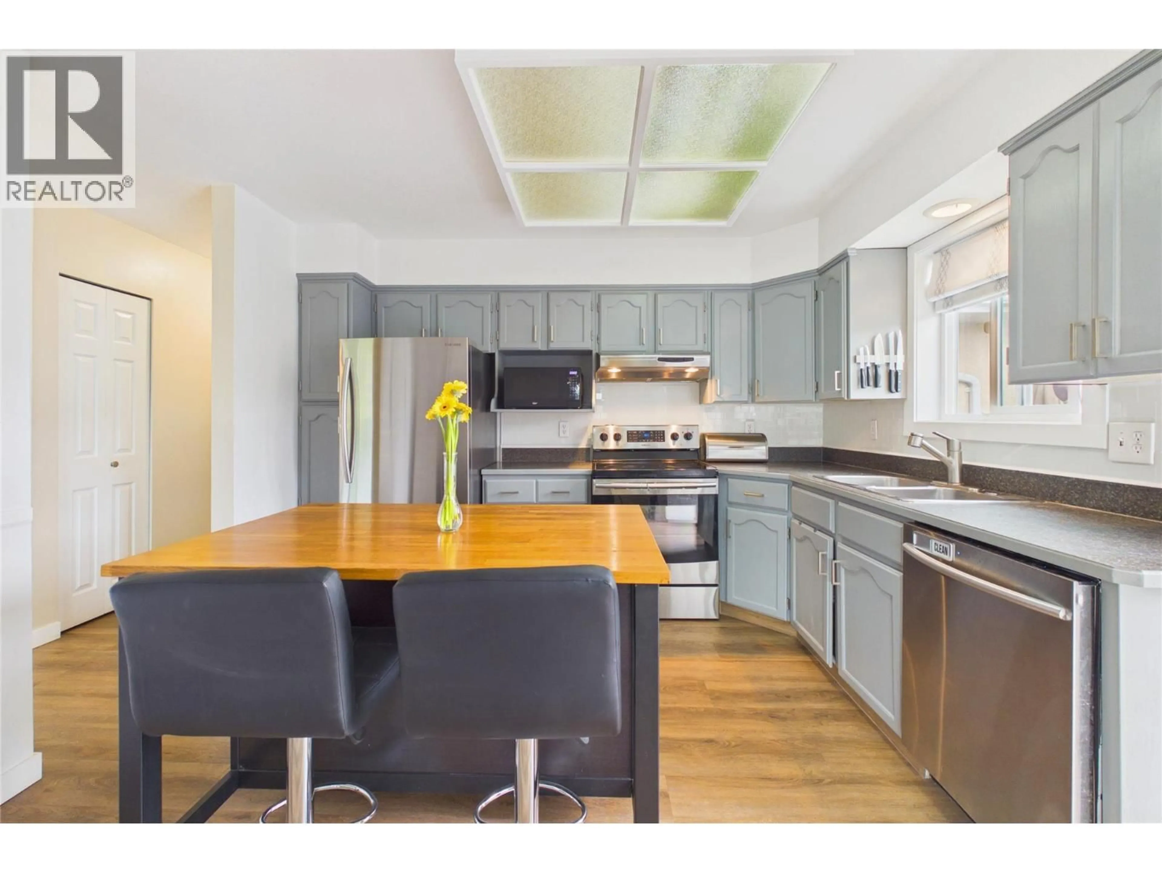 Open concept kitchen, wood/laminate floor for 148 TROY PLACE, Penticton British Columbia V2A7L5