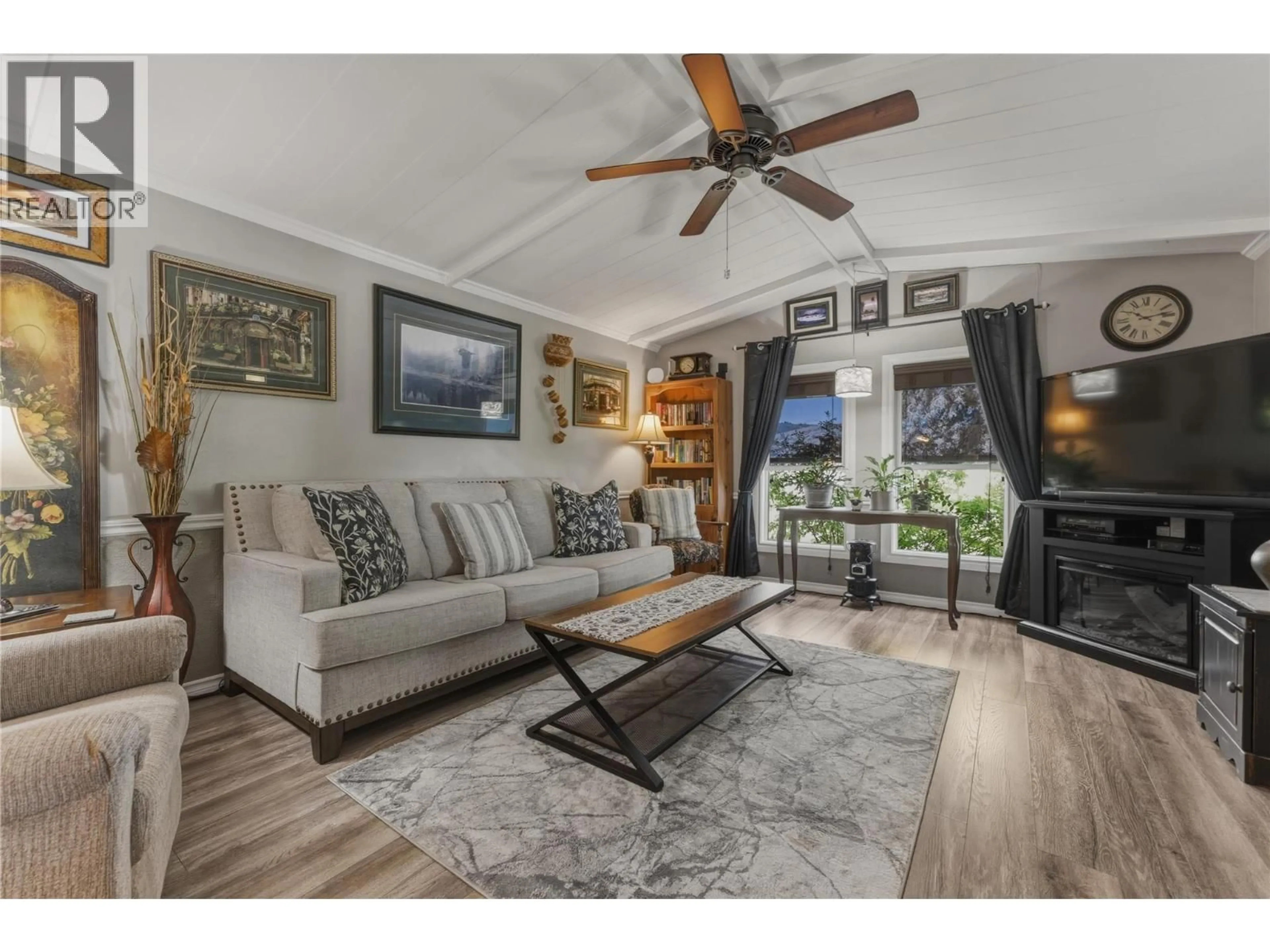 Living room with furniture, wood/laminate floor for 6960 PLEASANT VALLEY ROAD, Vernon British Columbia V1B3R5