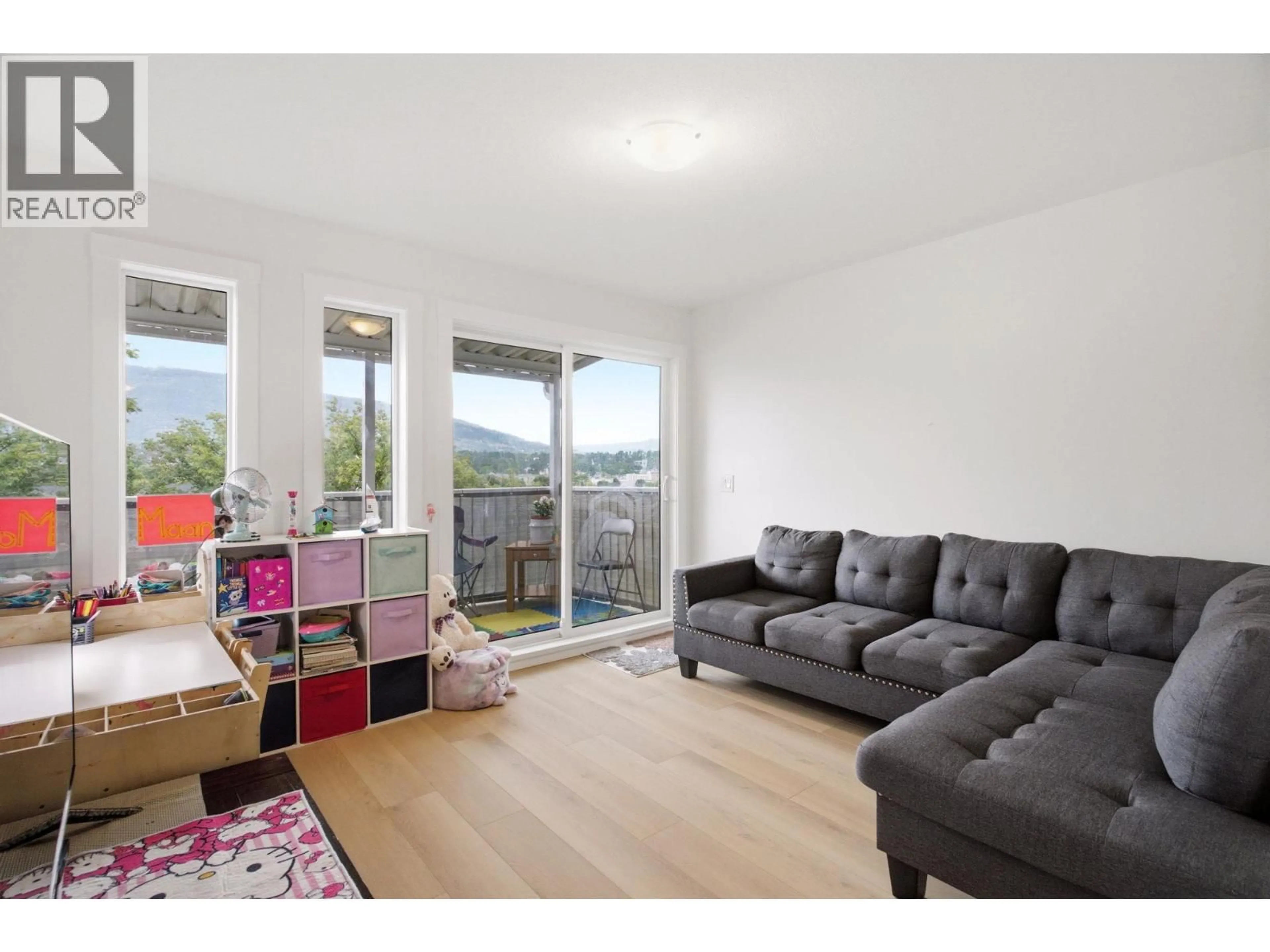 Living room with furniture, wood/laminate floor for 207 - 4004 34 STREET, Vernon British Columbia V1T5Y2