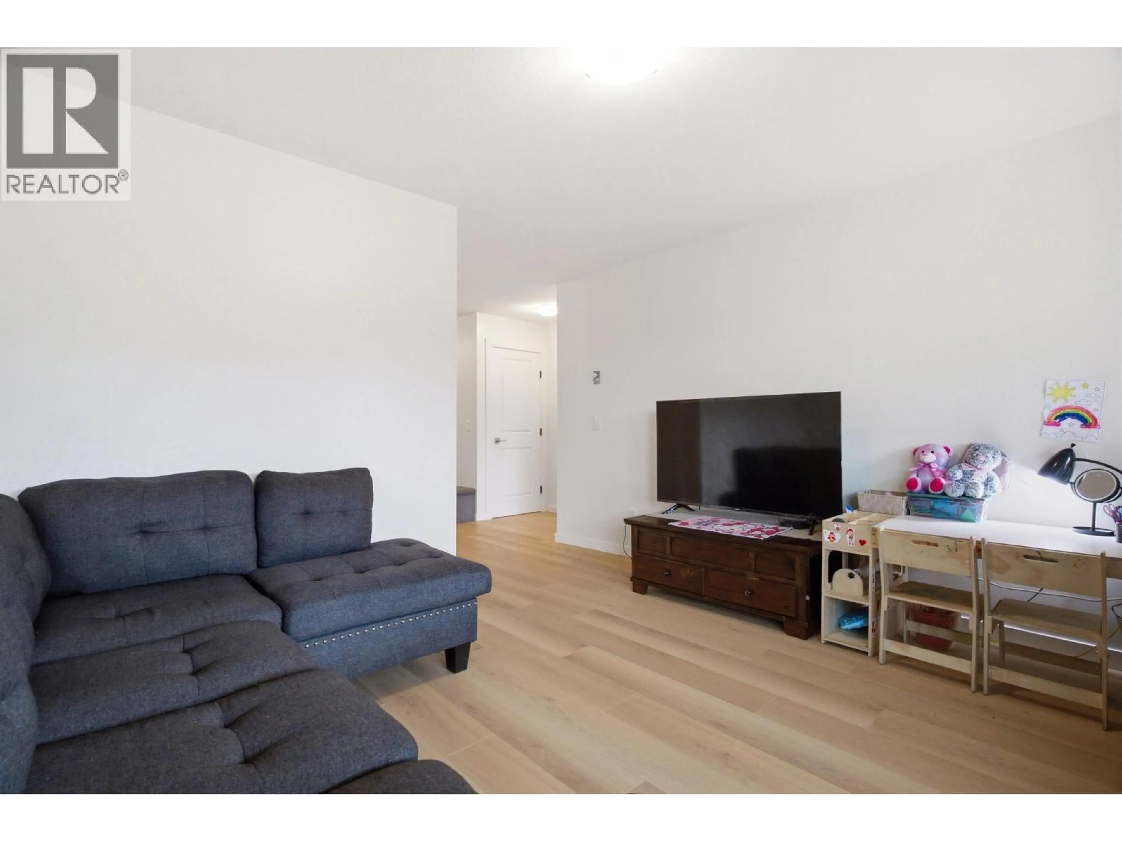 Living room with furniture, wood/laminate floor for 207 - 4004 34 STREET, Vernon British Columbia V1T5Y2