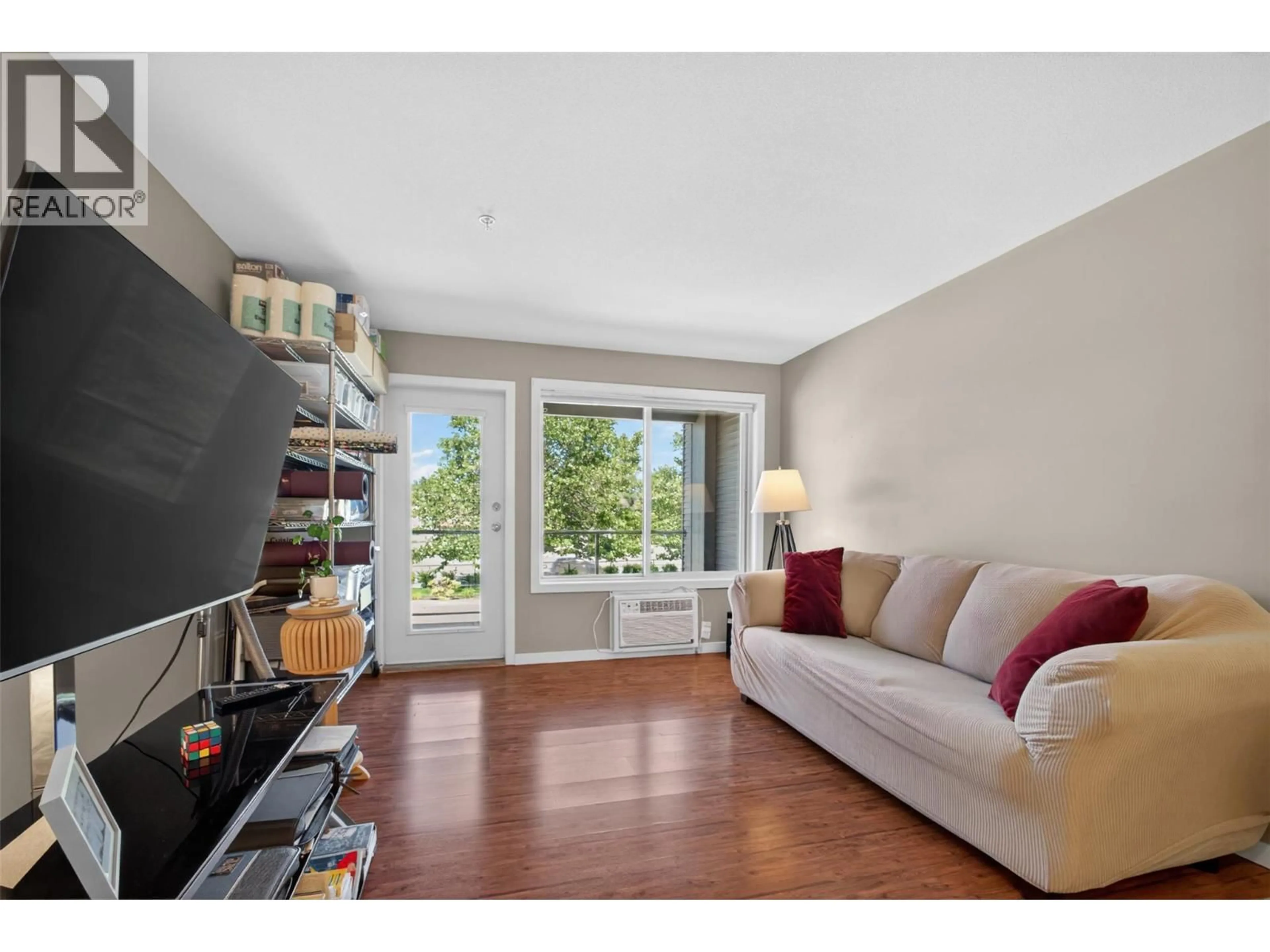 Living room with furniture, wood/laminate floor for 204 - 135 ZIPRICK ROAD, Kelowna British Columbia V1X8B2