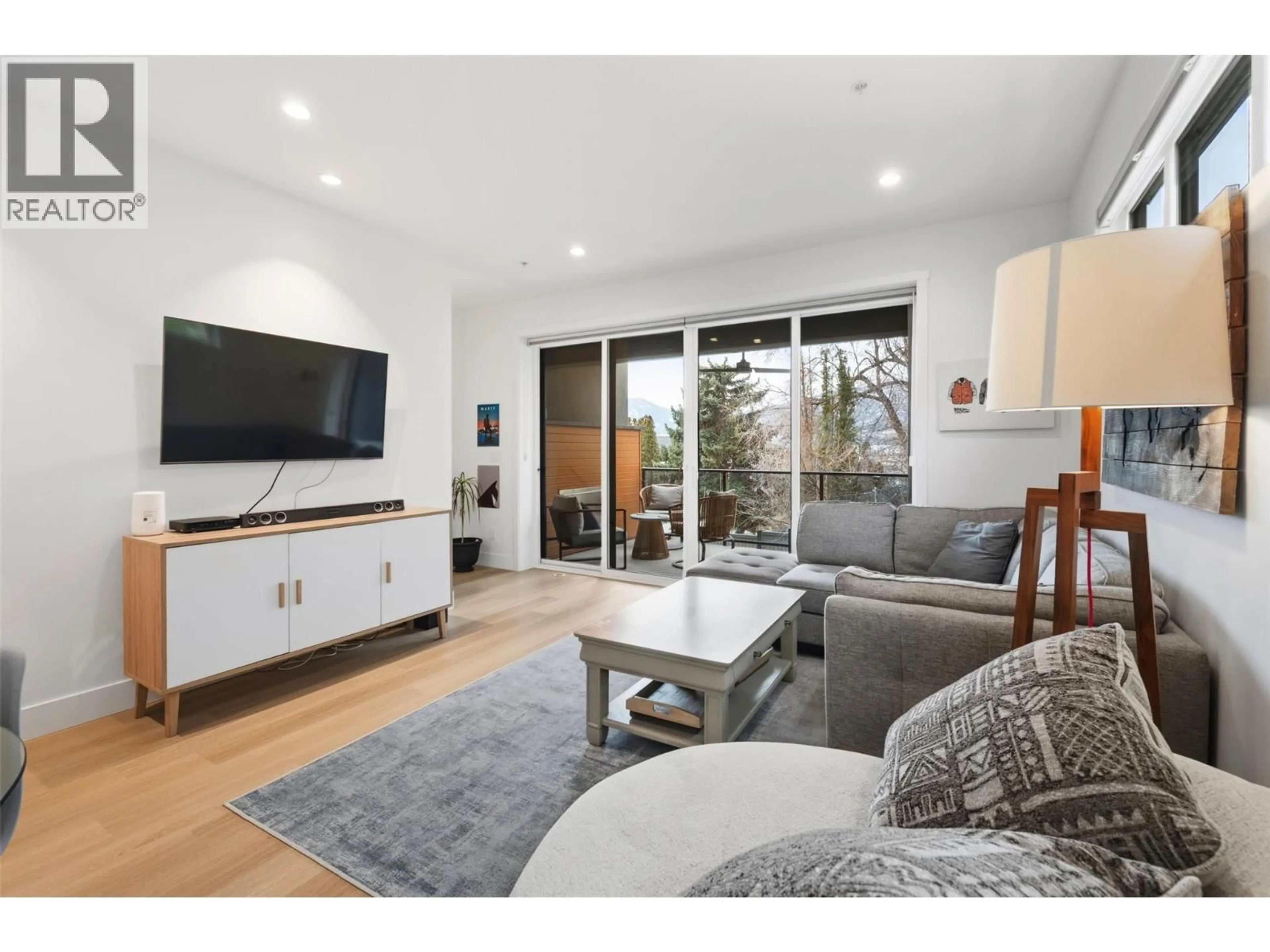 Living room with furniture, wood/laminate floor for 108 - 555 WADE AVENUE EAST, Penticton British Columbia V2A1T2