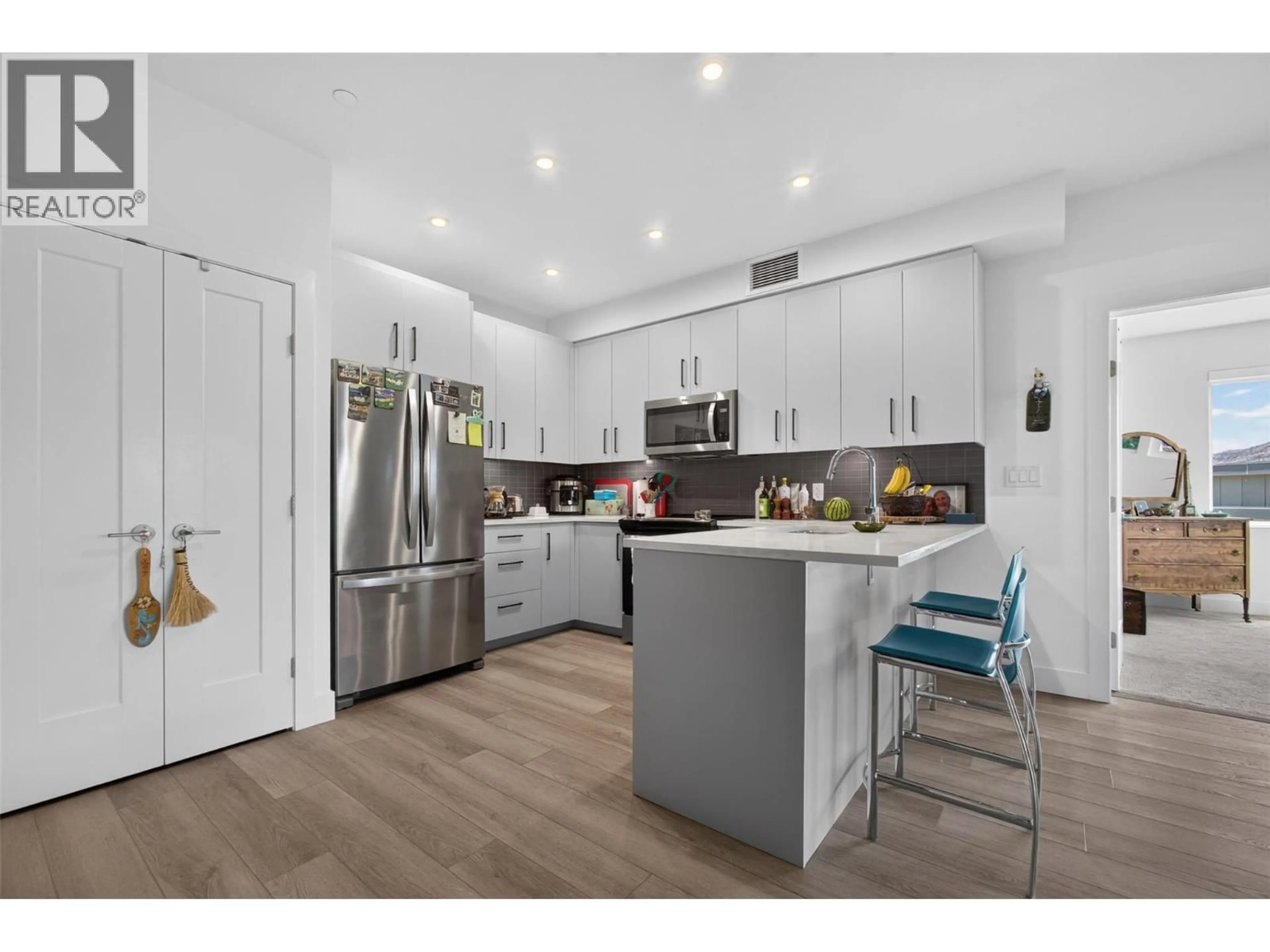 Open concept kitchen, wood/laminate floor for 101 - 3434 MCKINLEY BEACH DRIVE, Kelowna British Columbia V1V0H3