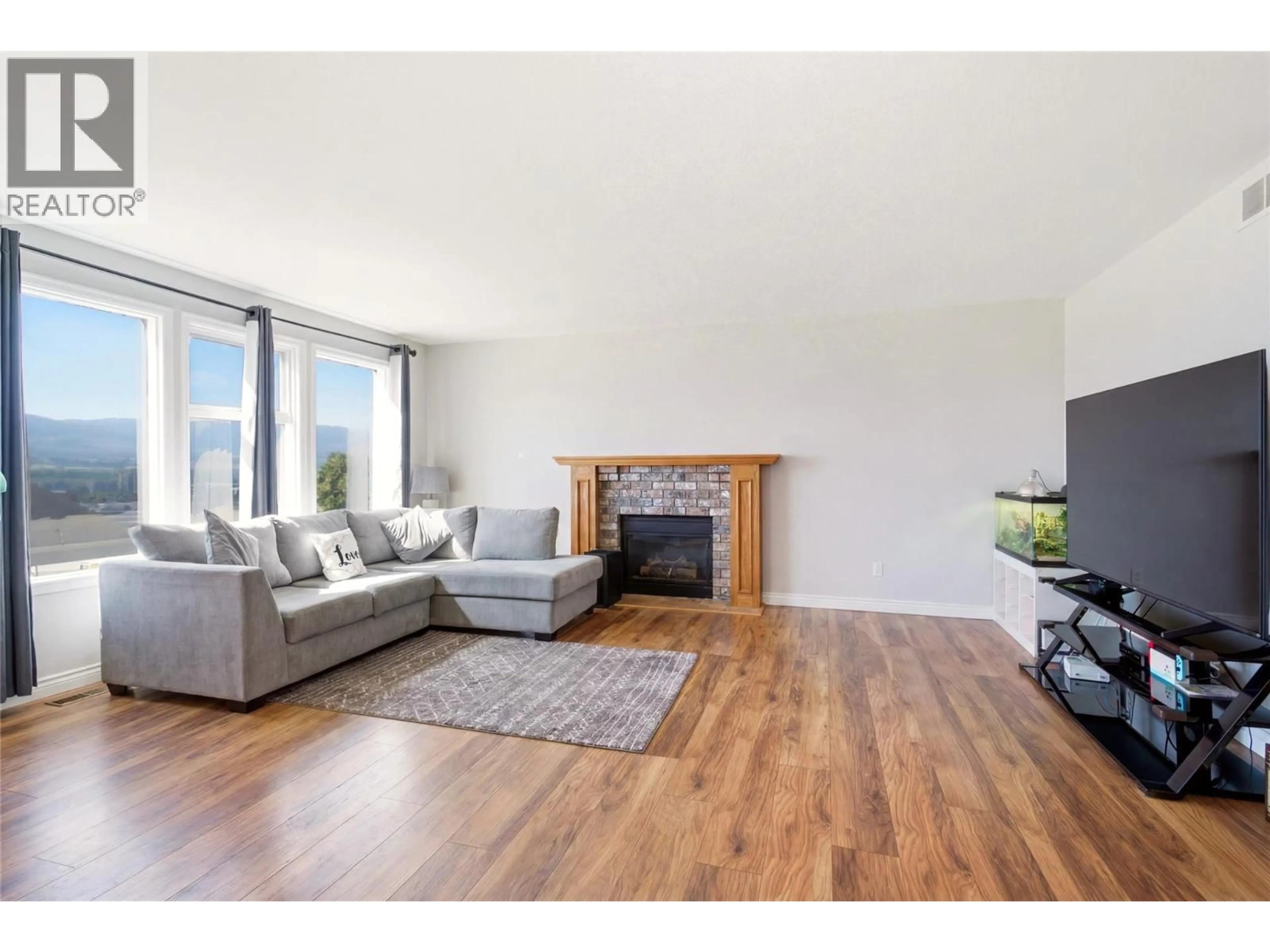 Living room with furniture, wood/laminate floor for 2260 OMINECA PLACE, Kelowna British Columbia V1V1H7