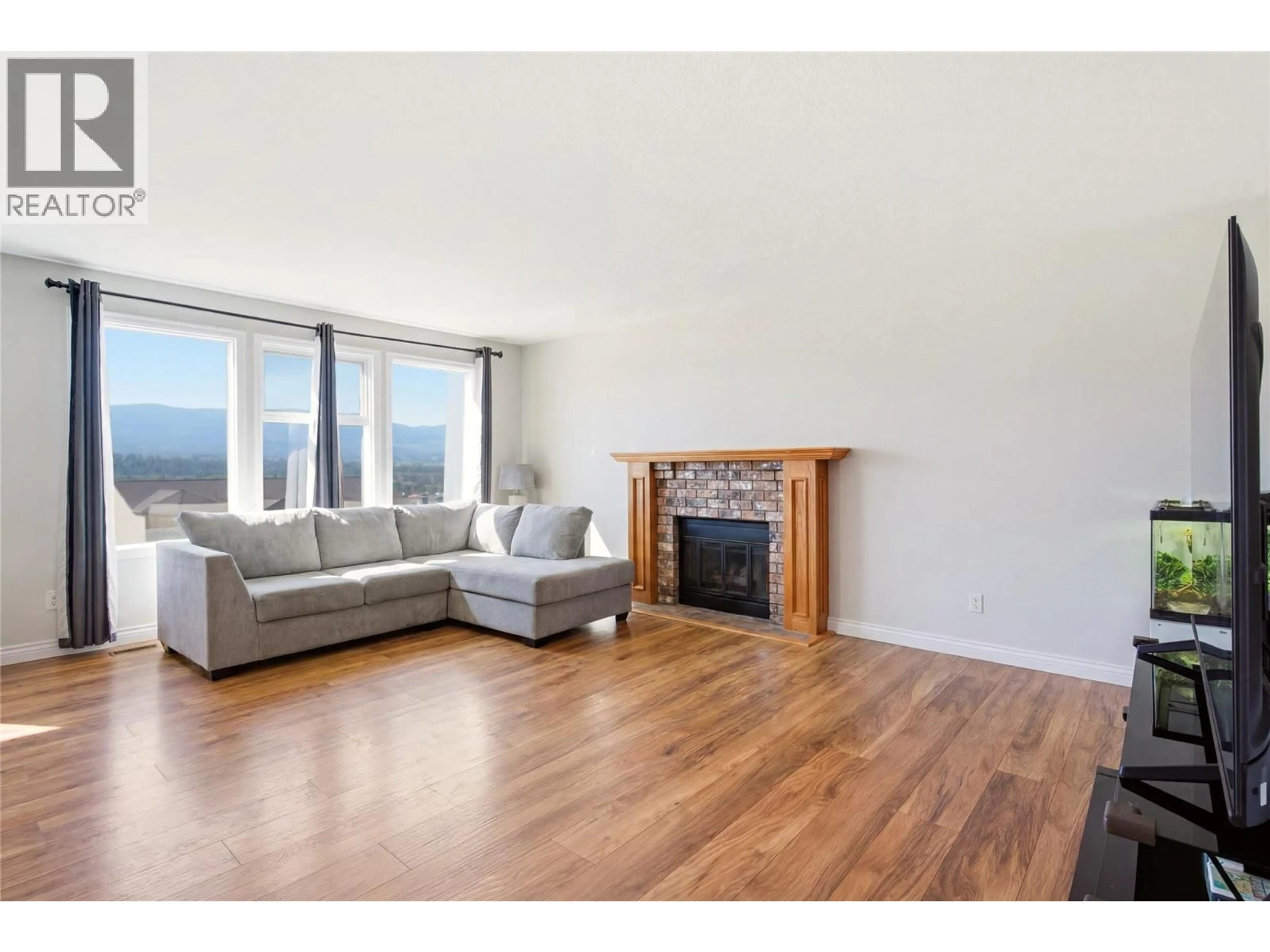 Living room with furniture, wood/laminate floor for 2260 OMINECA PLACE, Kelowna British Columbia V1V1H7