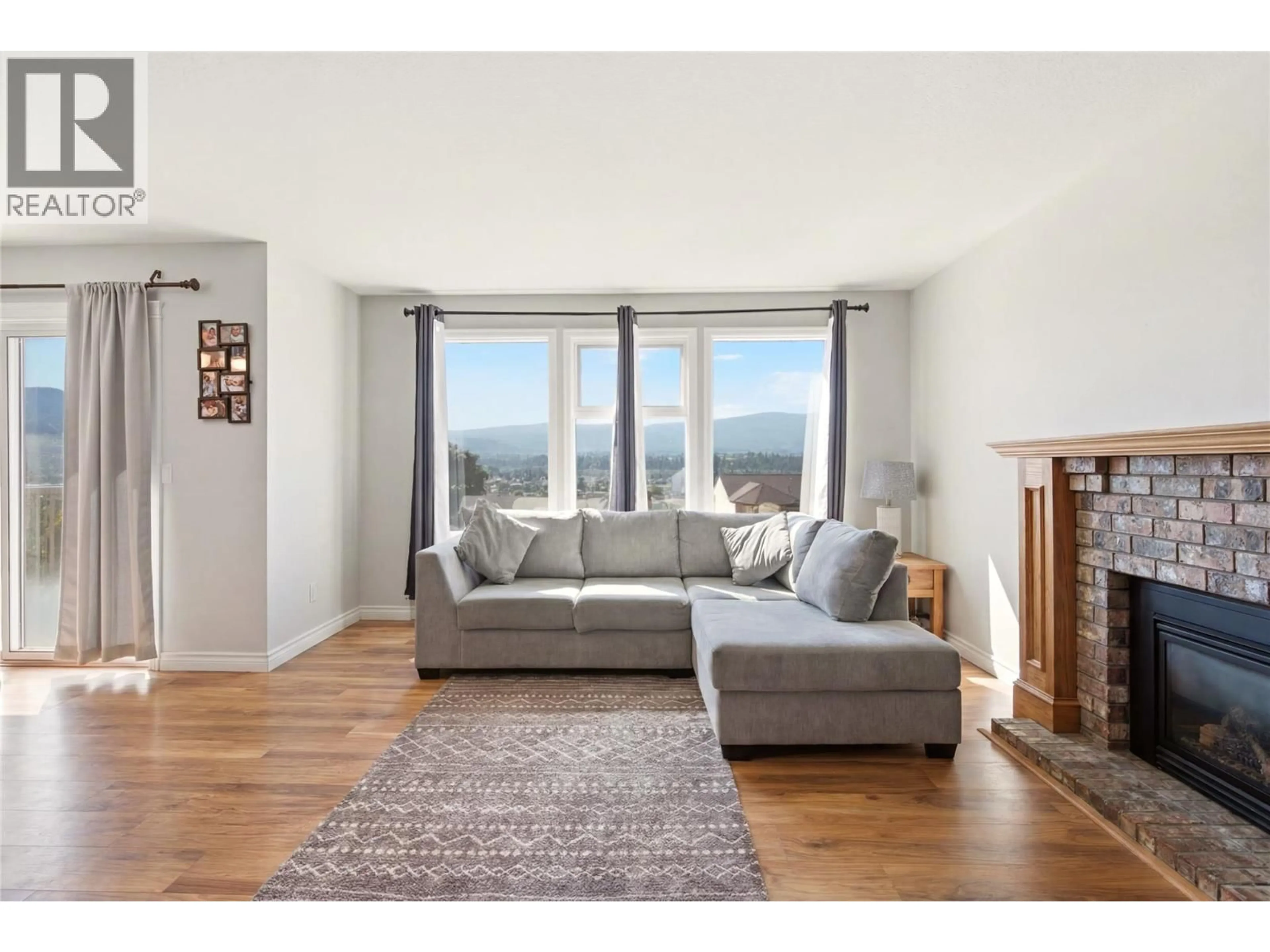 Living room with furniture, wood/laminate floor for 2260 OMINECA PLACE, Kelowna British Columbia V1V1H7