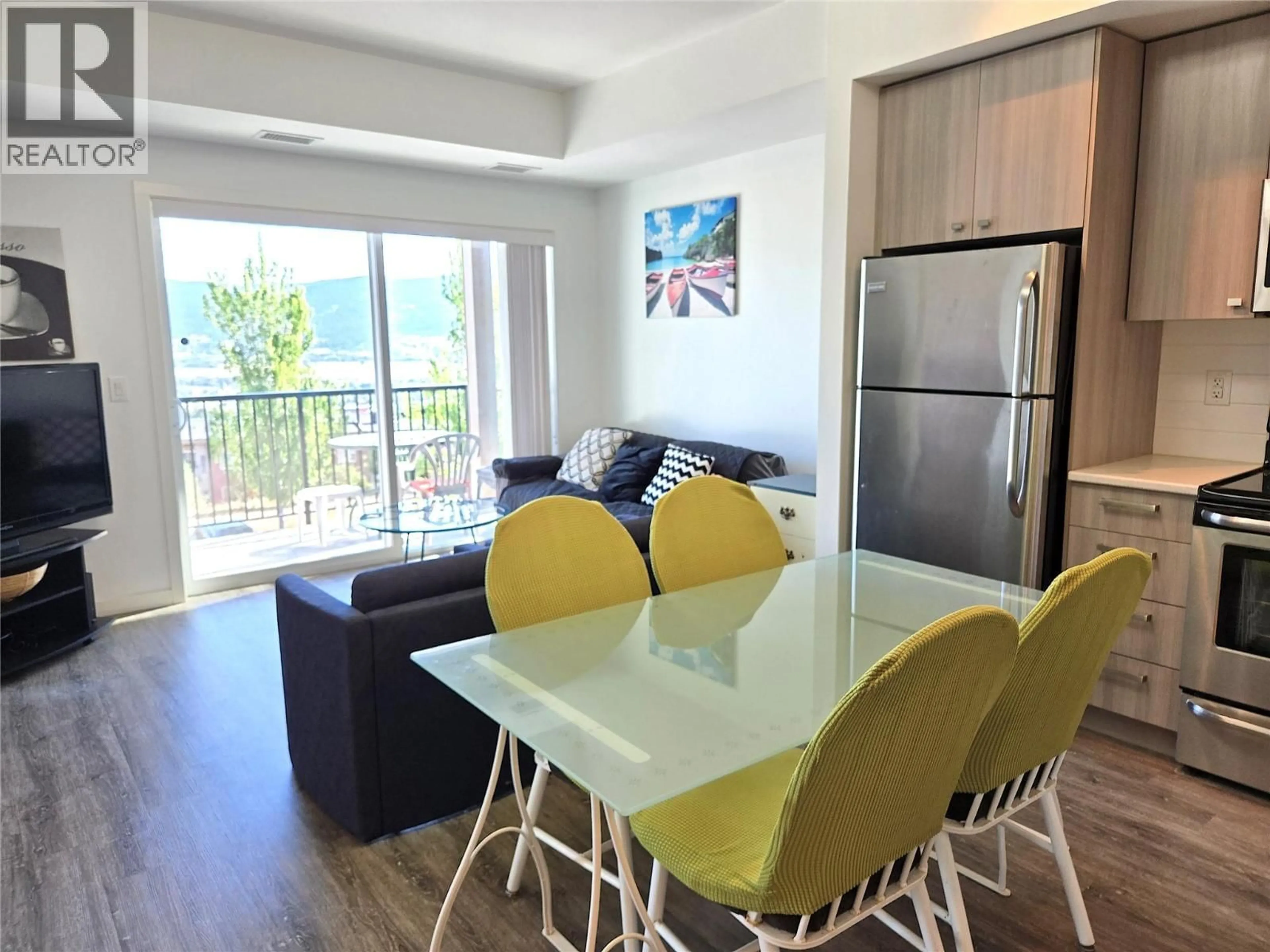 Living room with furniture, wood/laminate floor for 202 - 935 ACADEMY WAY, Kelowna British Columbia V1V3C9
