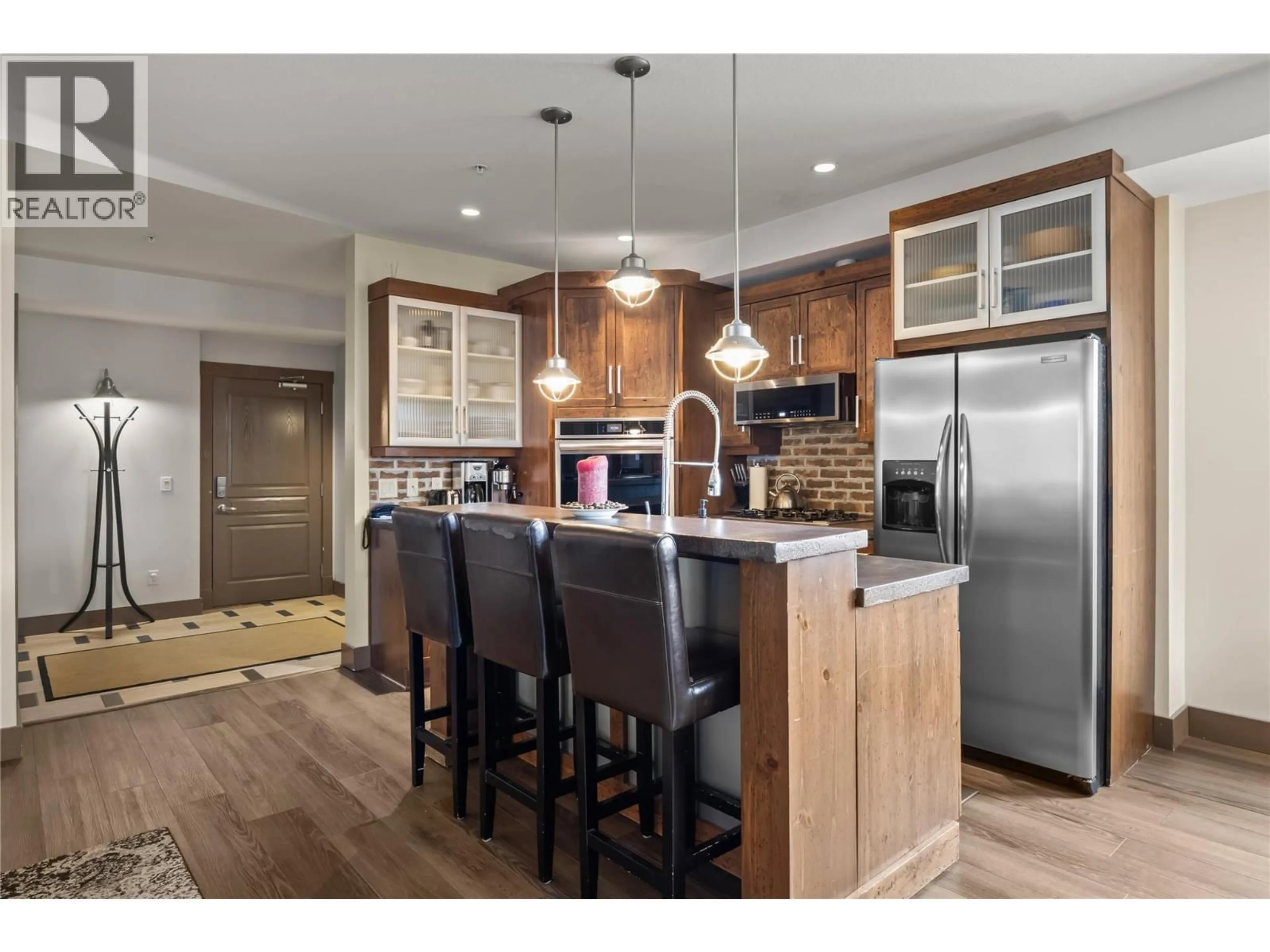 Open concept kitchen, wood/laminate floor for 101 - 5085 SNOWBIRD WAY, Big White British Columbia V1P1P3