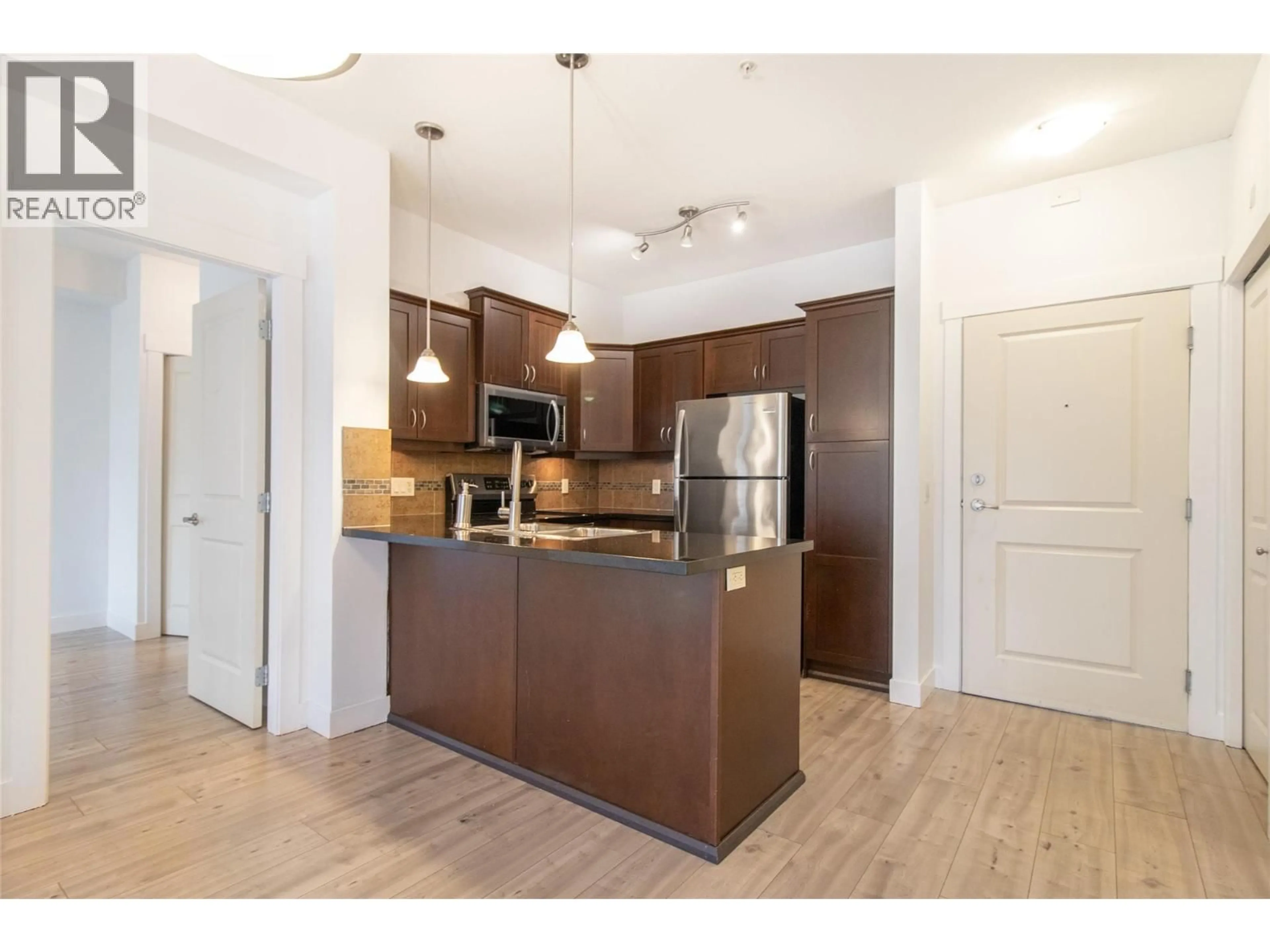 Open concept kitchen, wood/laminate floor for 311 - 3521 CARRINGTON ROAD, West Kelowna British Columbia V4T2E6